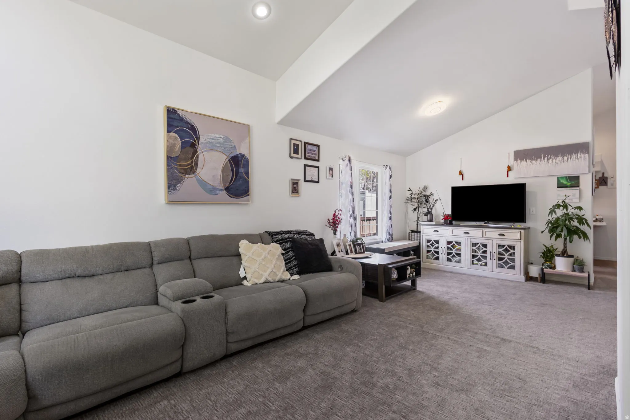 Carpeted living room with vaulted ceiling