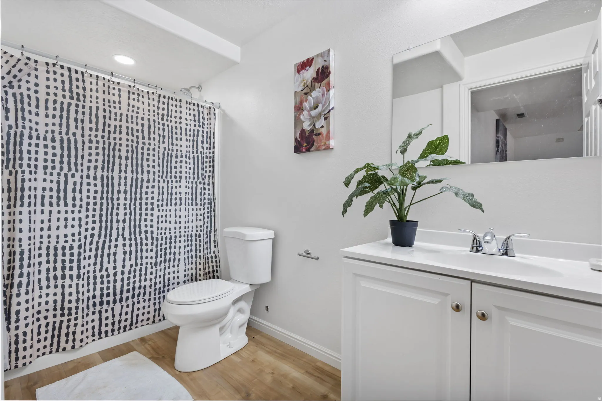 Full bathroom featuring vanity, light wood finished floors, a shower with curtain, and recessed lighting