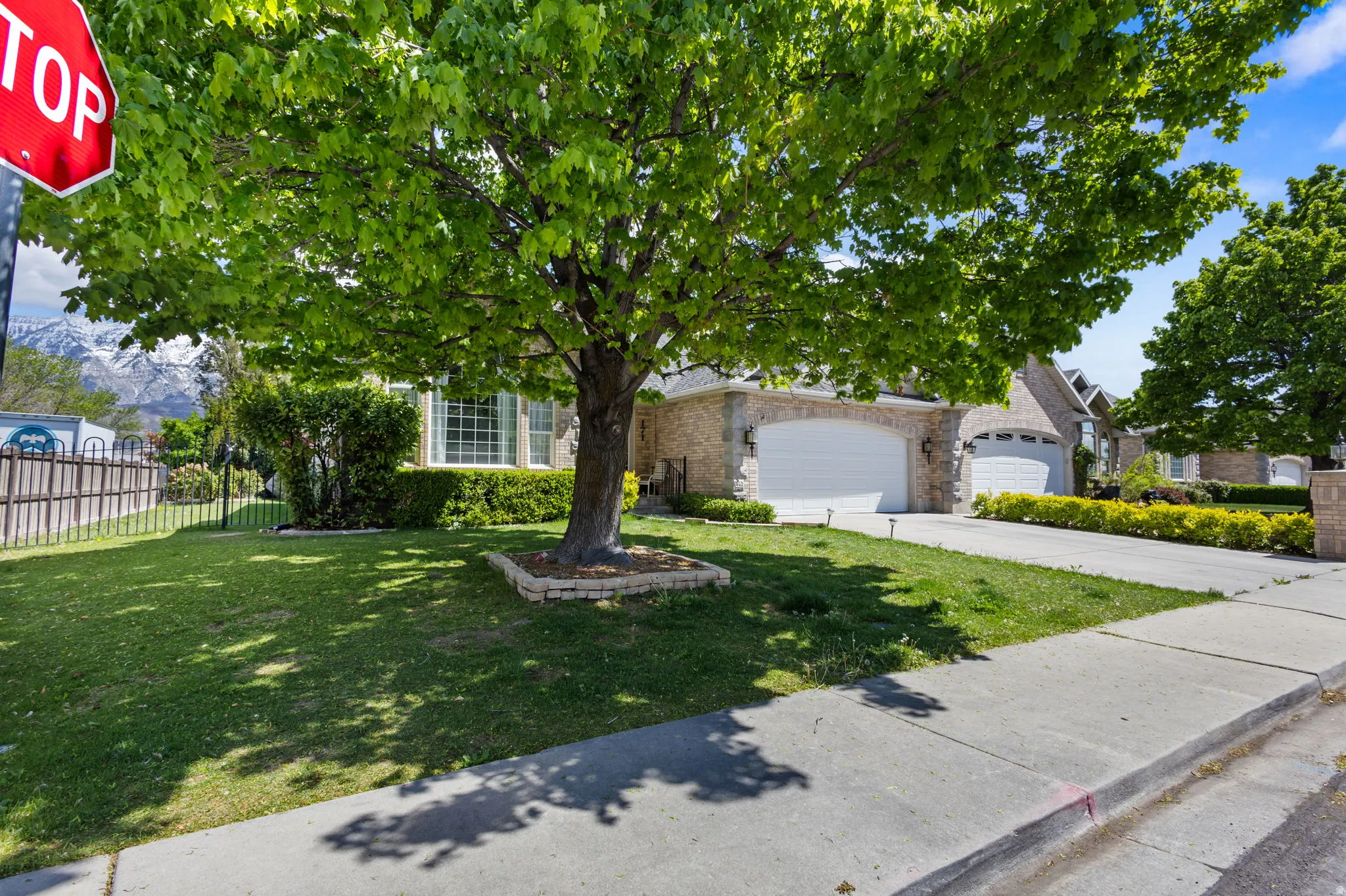 Obstructed view of property with concrete driveway, a garage, and stone siding