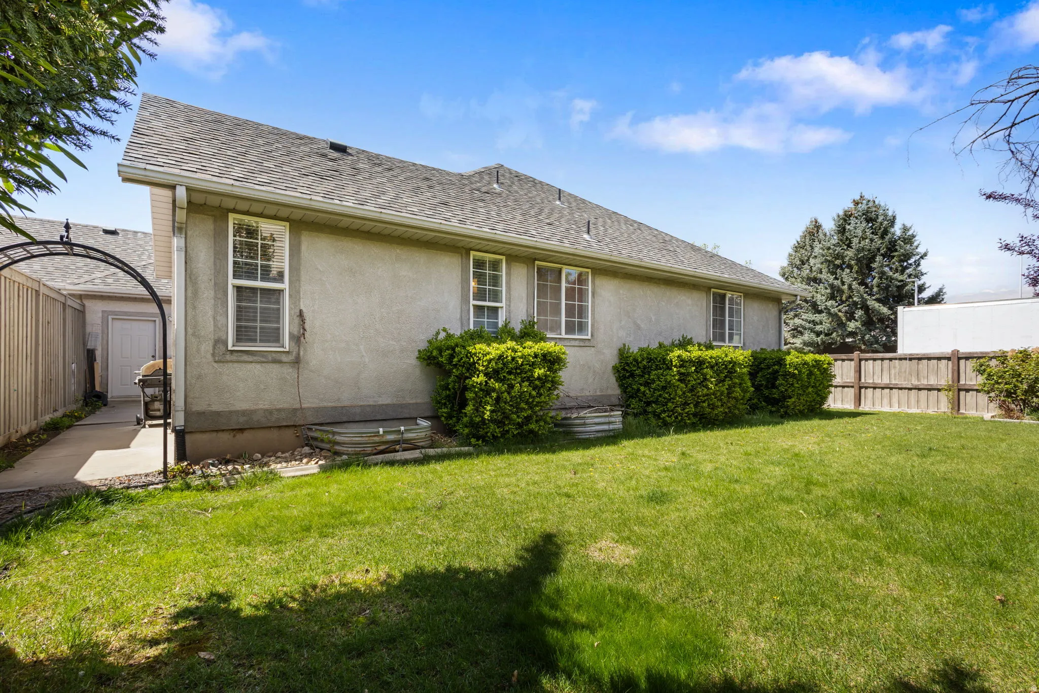Rear view of property featuring a fenced backyard, stucco siding, and a shingled roof