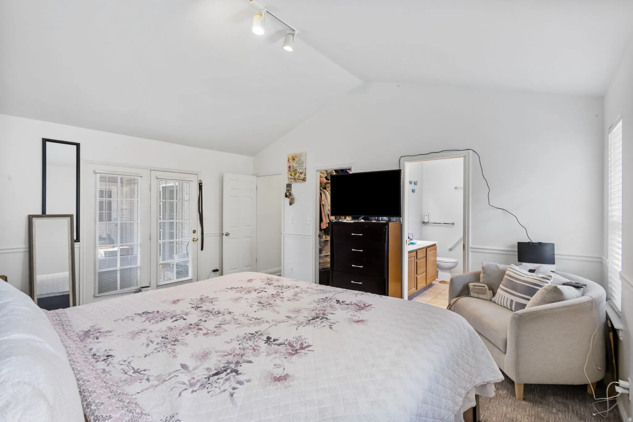 Bedroom featuring a walk in closet, track lighting, and ensuite bath