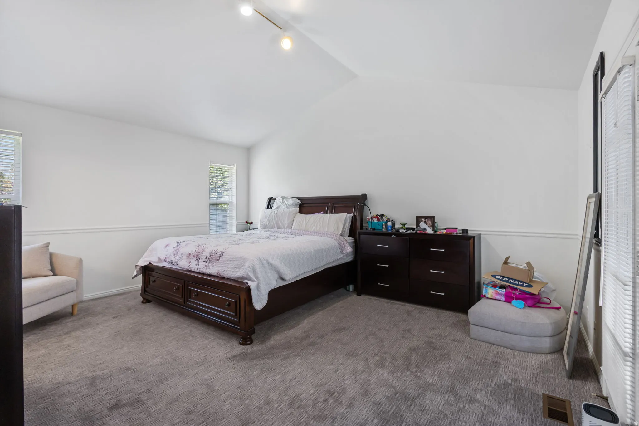 Carpeted bedroom featuring vaulted ceiling