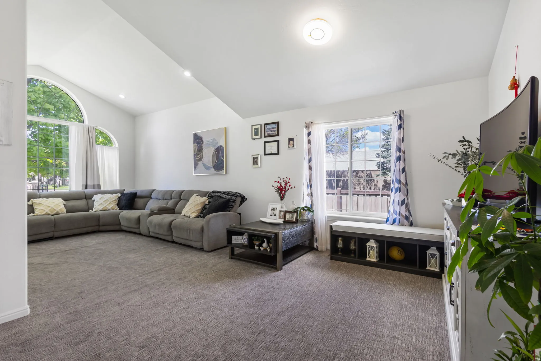 Living room featuring vaulted ceiling, dark carpet, and recessed lighting