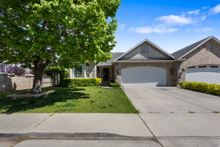 View of front of home with an attached garage, brick siding, concrete driveway, and a shingled roof