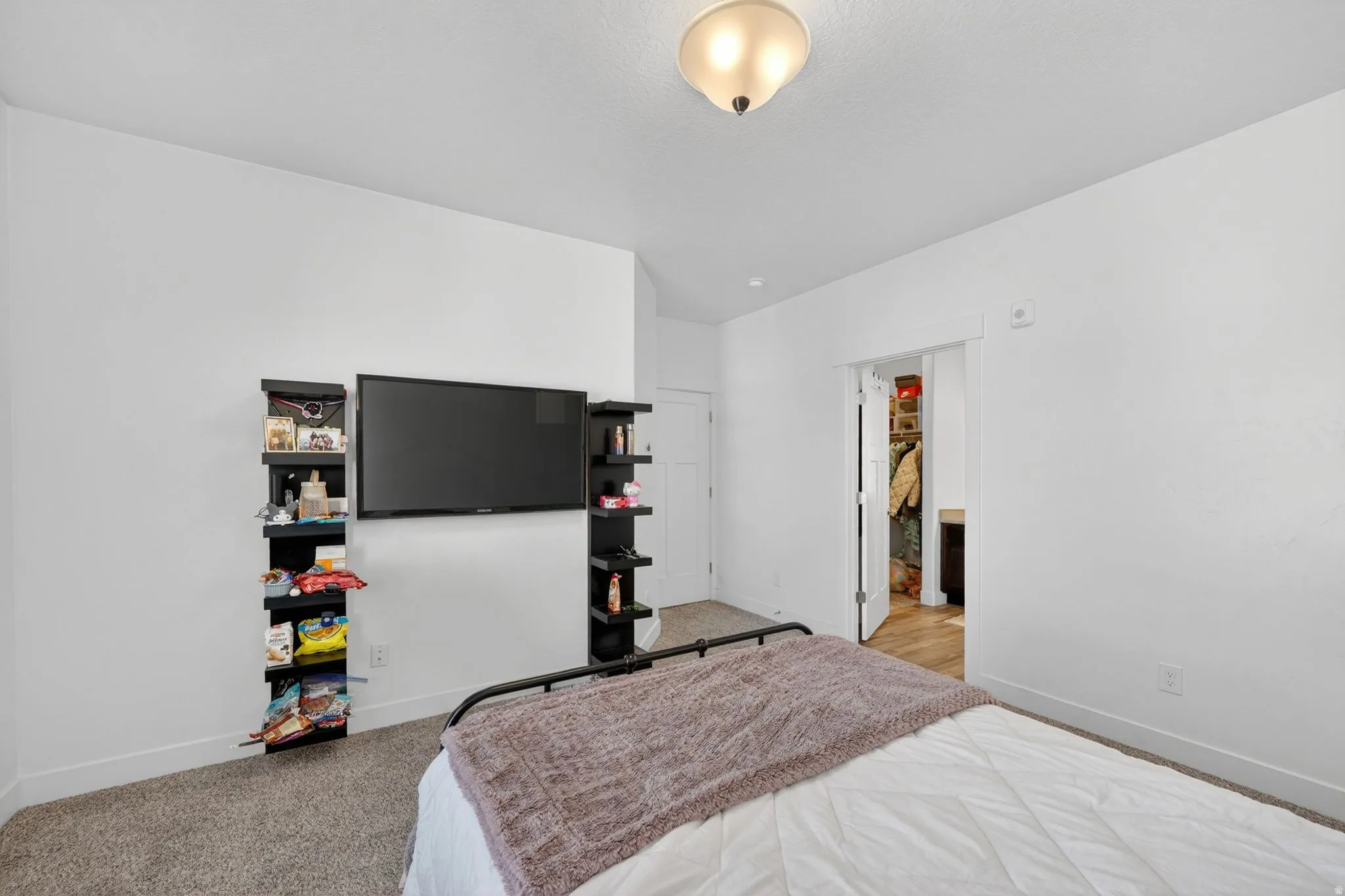Bedroom featuring light colored carpet and baseboards