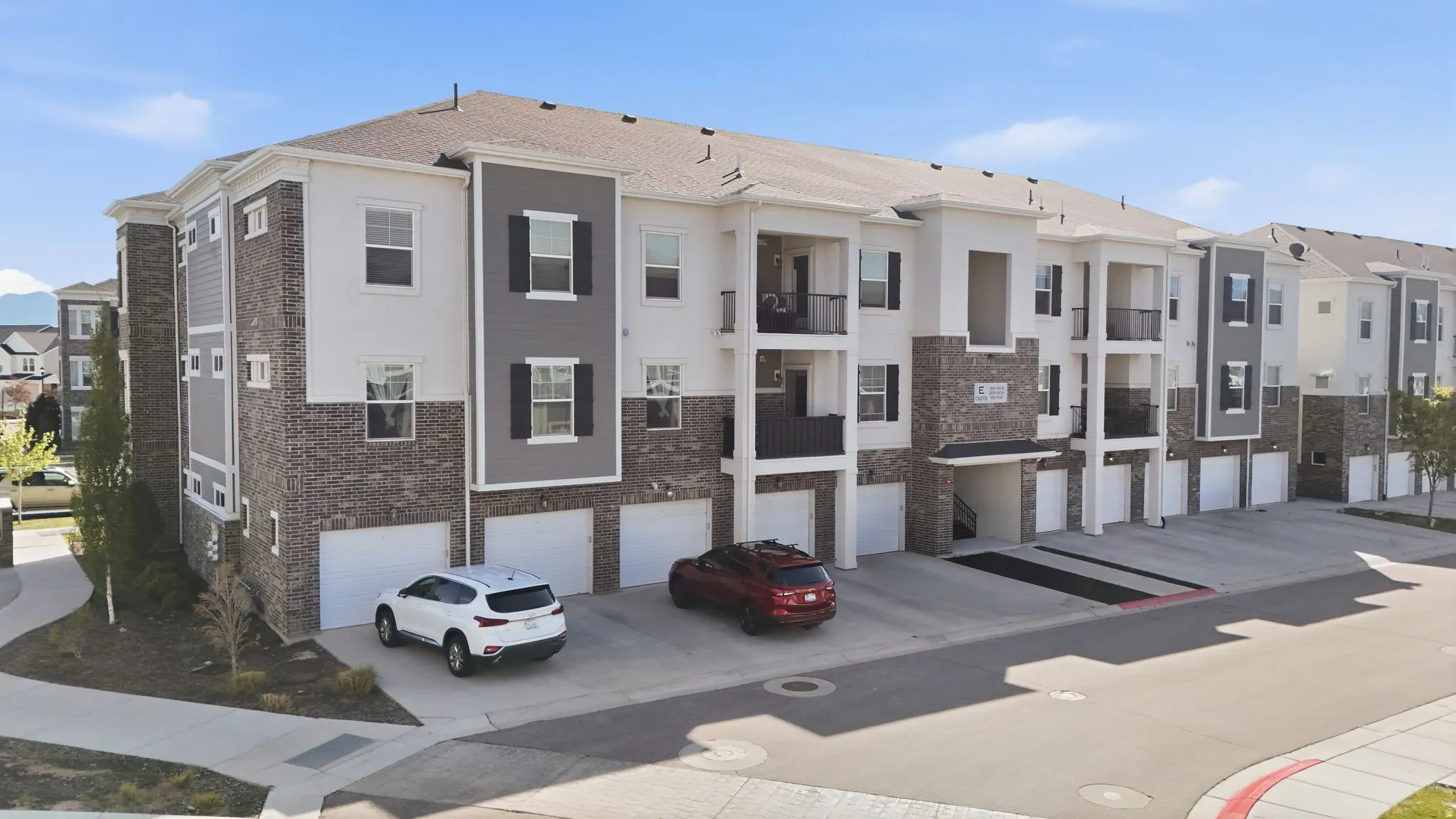 View of property with a garage, driveway, and a residential view