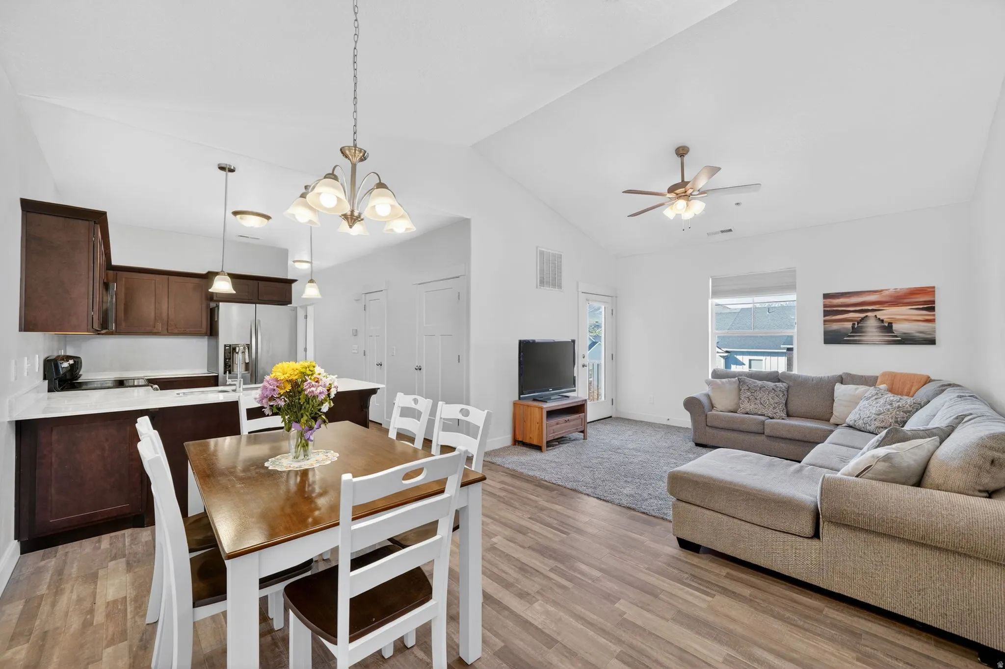 Dining space with a chandelier, light wood-type flooring, and a ceiling fan