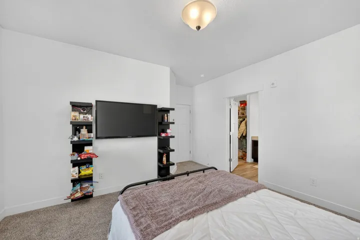 Bedroom featuring light colored carpet and baseboards