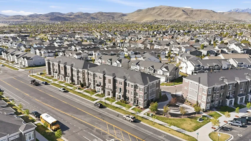 Aerial view of property and surrounding area with a mountainous background and nearby suburban area