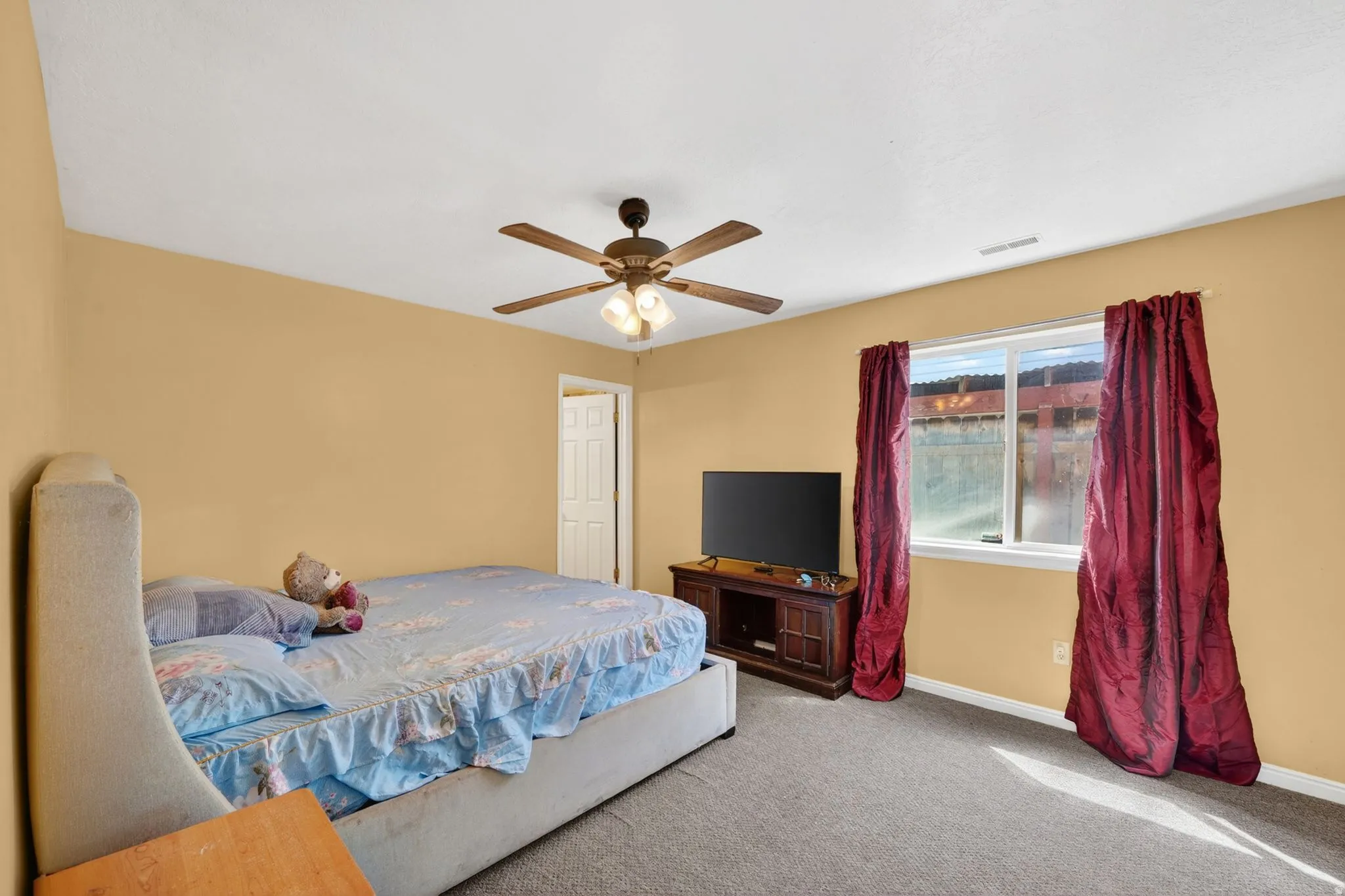 Carpeted bedroom with baseboards and ceiling fan