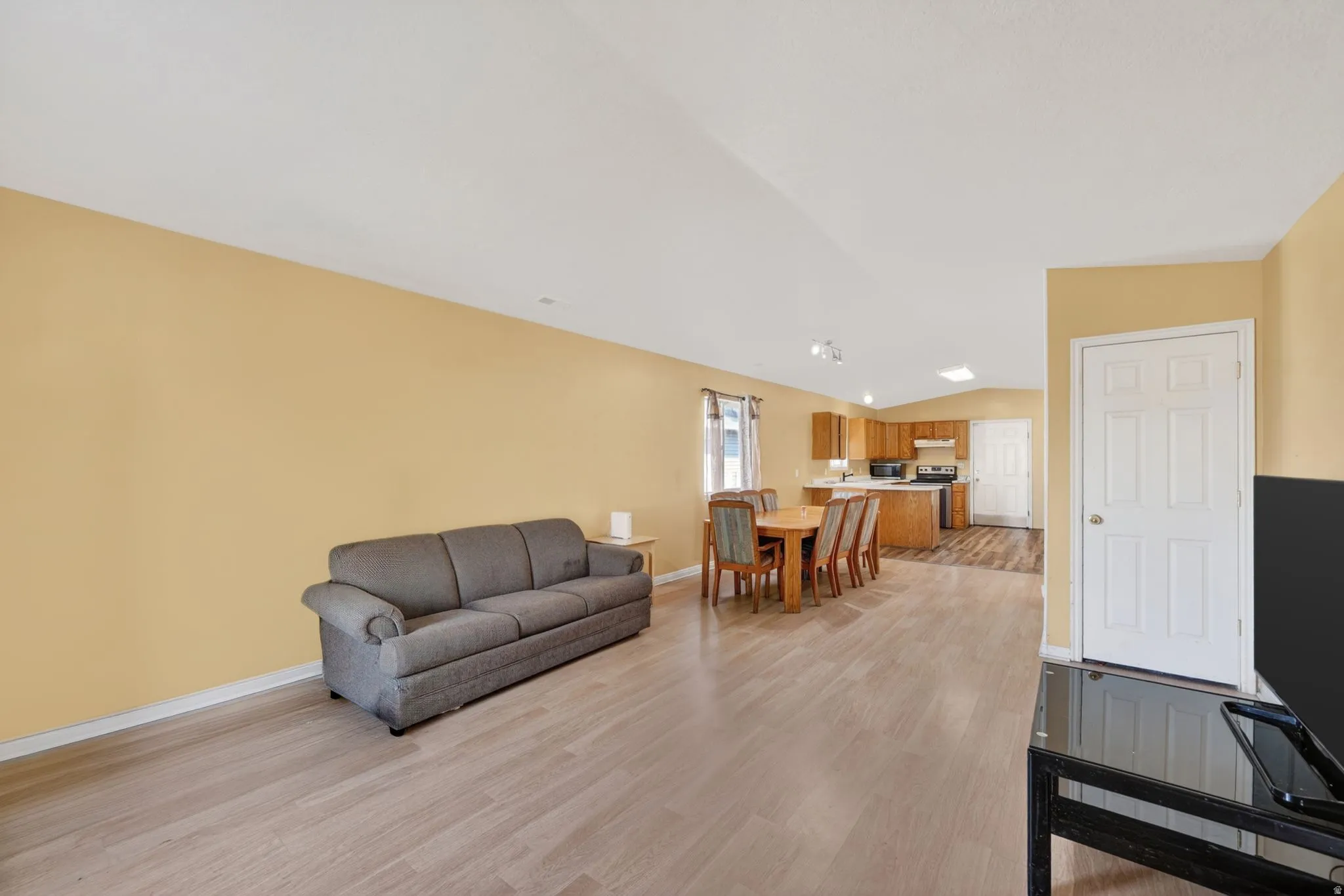 Living area with lofted ceiling and light wood-type flooring