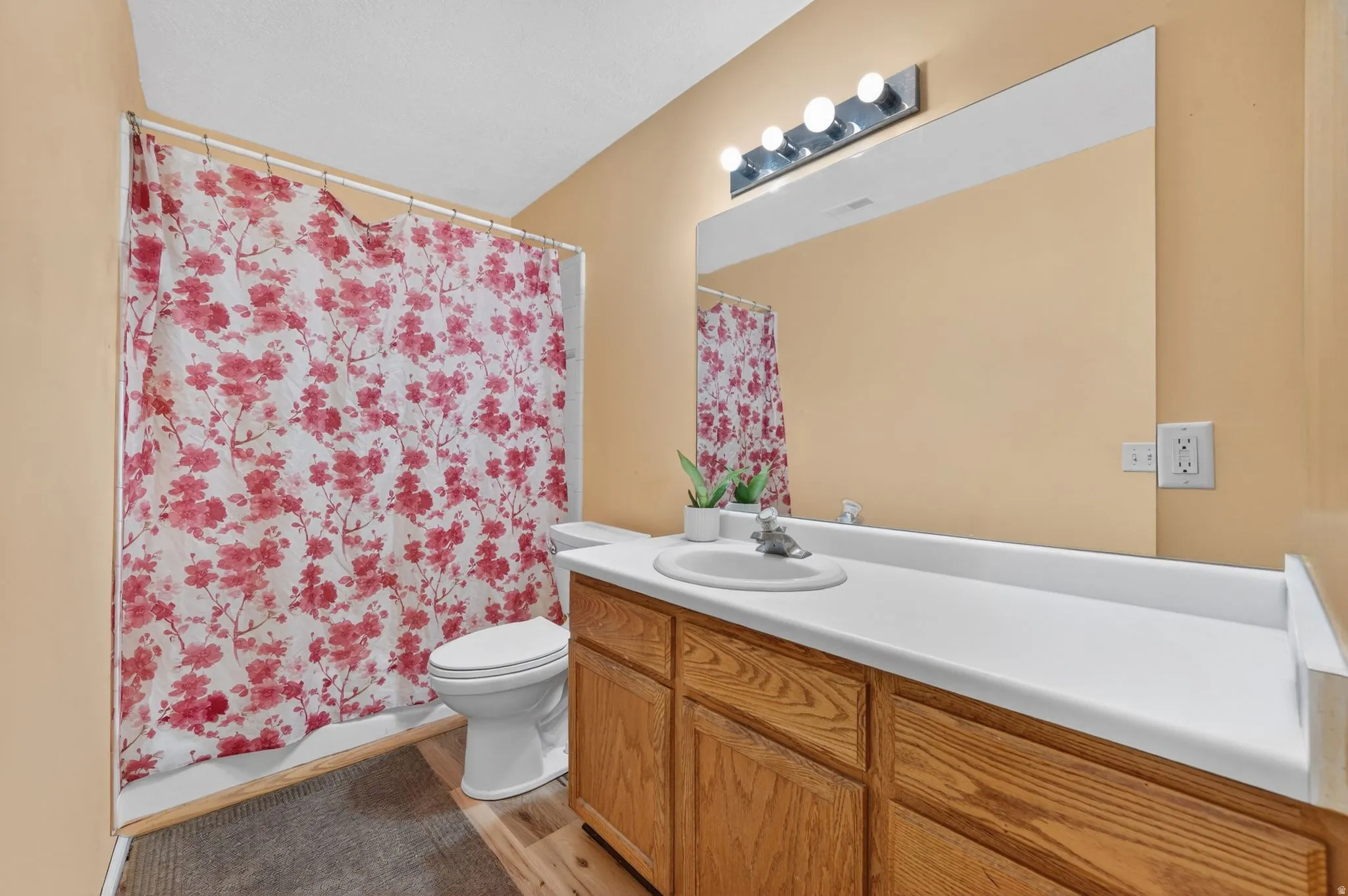Full bathroom featuring vanity, light wood finished floors, and shower / bathtub combination with curtain
