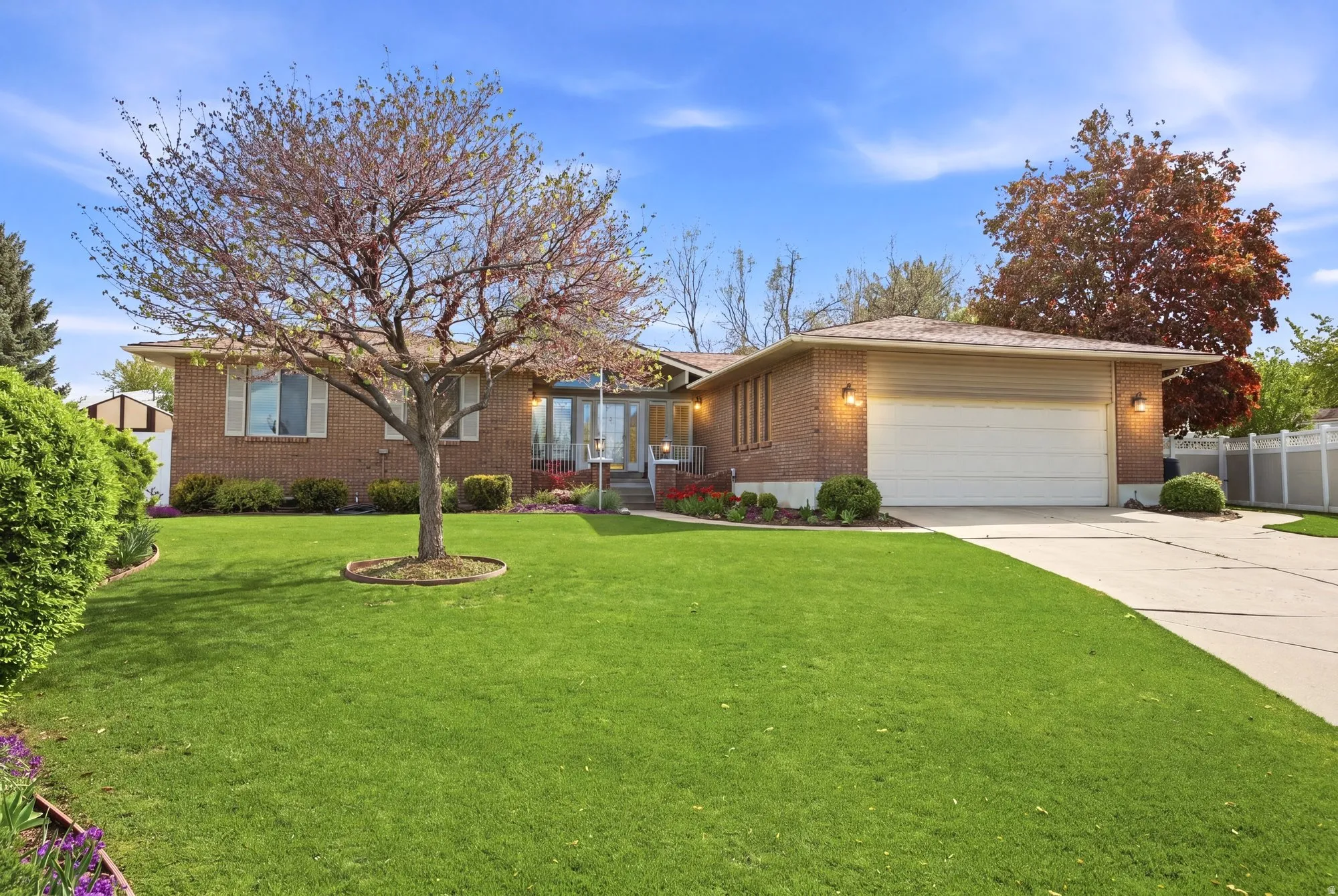Ranch-style house featuring a 2 car  garage, driveway, full brick exterior, and a immaculate  front yard