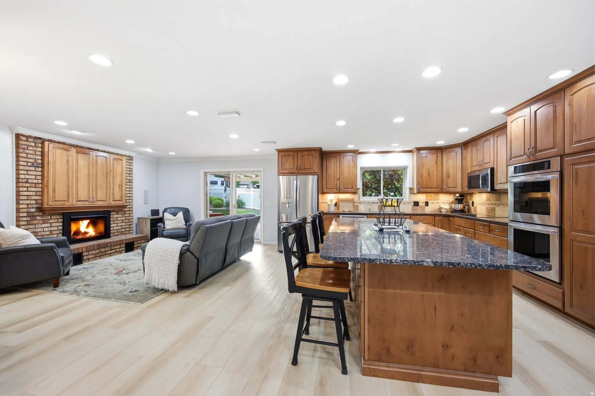 Kitchen  with open floor plan, a kitchen breakfast bar, a center island, under cabinet lighting and recessed lighting