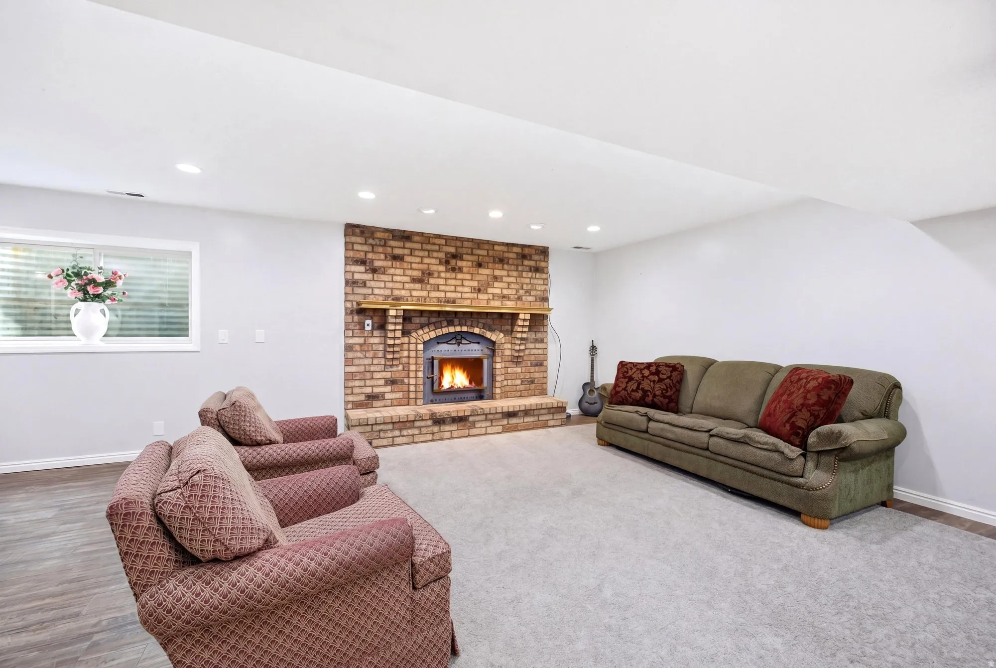 Basement apartment living room featuring a wood burning fireplace and recessed lighting