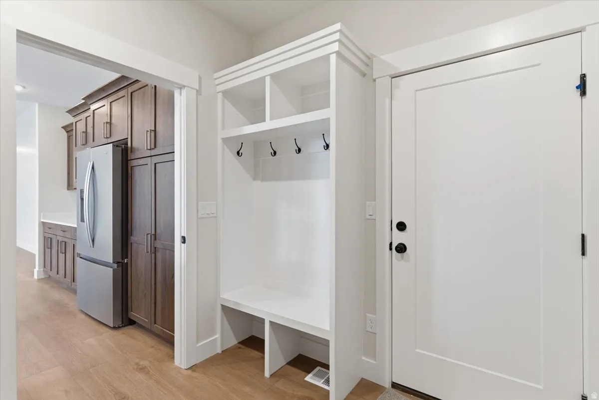 Mudroom with light wood-style floors and baseboards