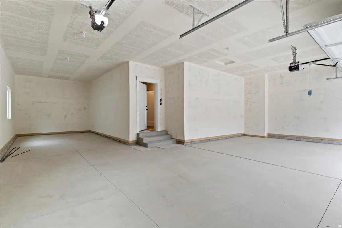 Garage featuring baseboards and a garage door opener