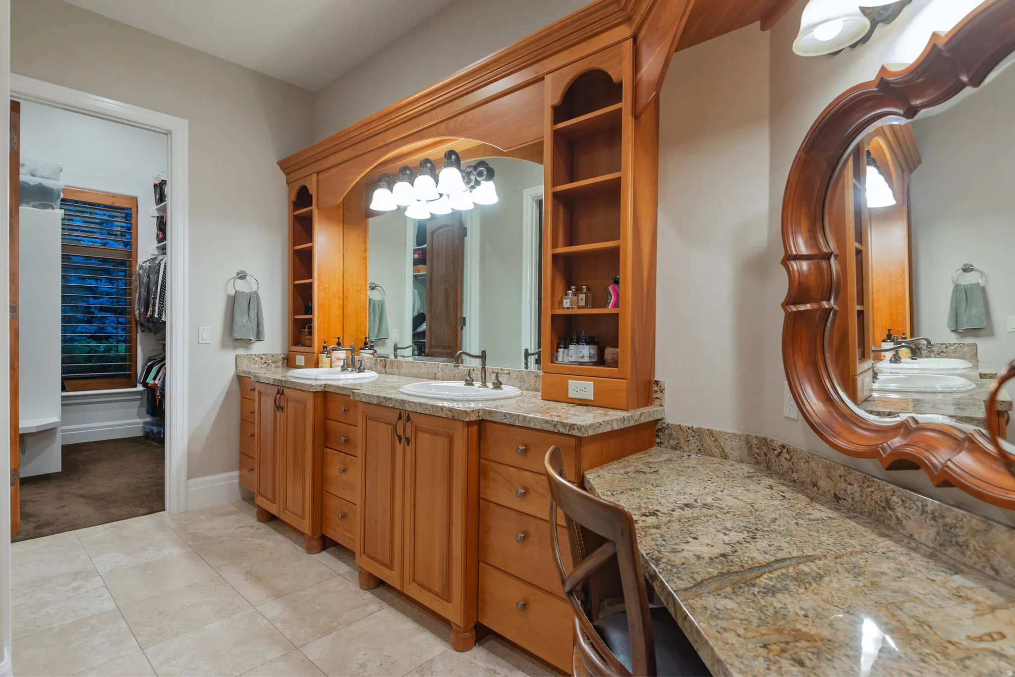 Full bath featuring double vanity, a spacious closet, and light tile patterned flooring