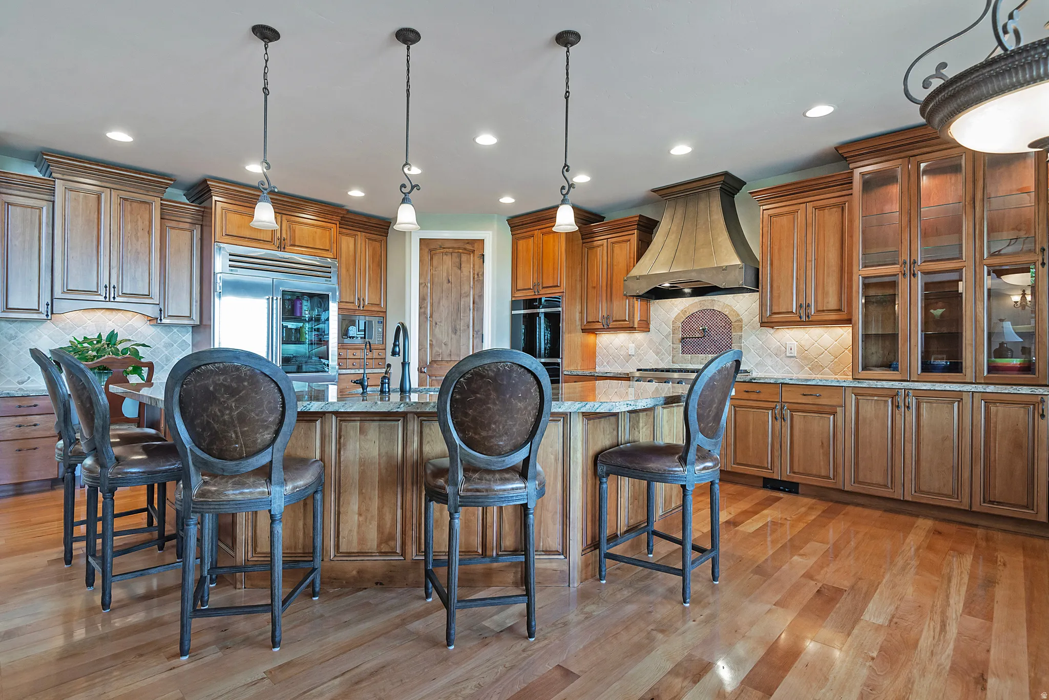 Kitchen featuring wood finish cabinetry, a kitchen breakfast bar, light wood-type flooring, and decorative light fixtures
