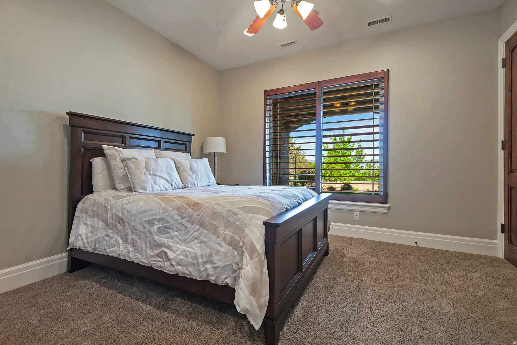 Carpeted bedroom with baseboards and ceiling fan