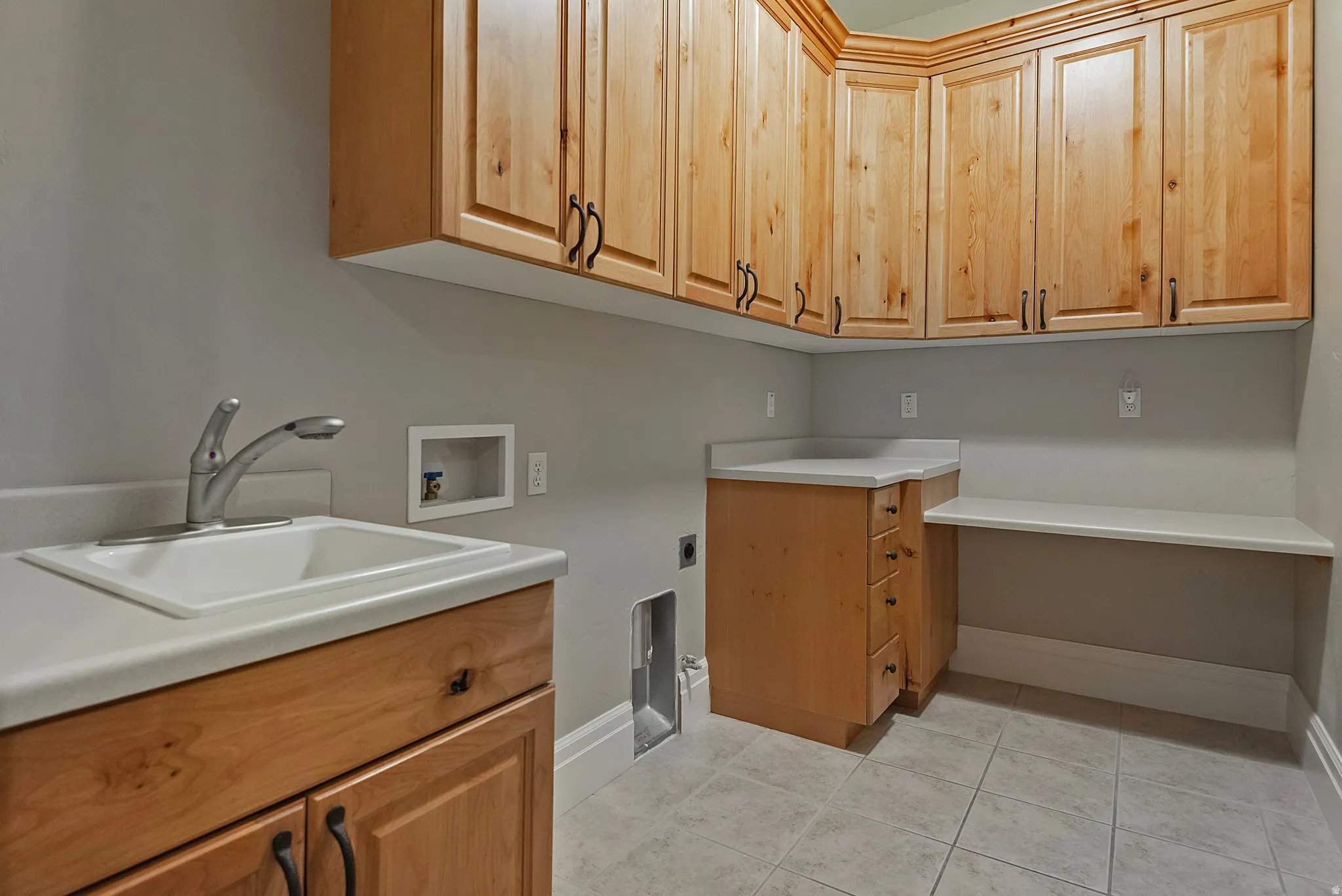 Laundry room with washer hookup, cabinet space, light tile patterned floors, and hookup for an electric dryer