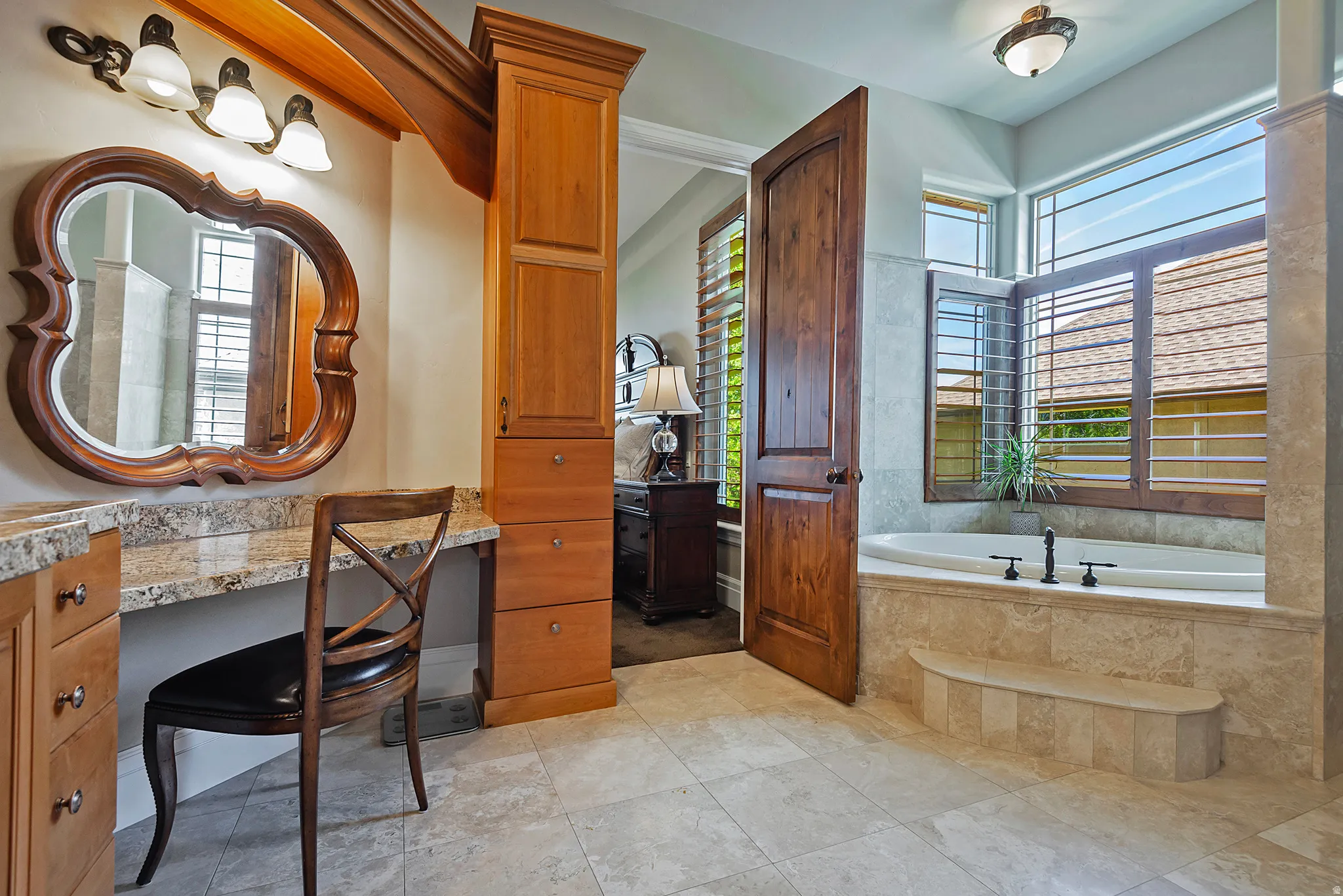 Bathroom featuring plenty of natural light, a bath, and vanity