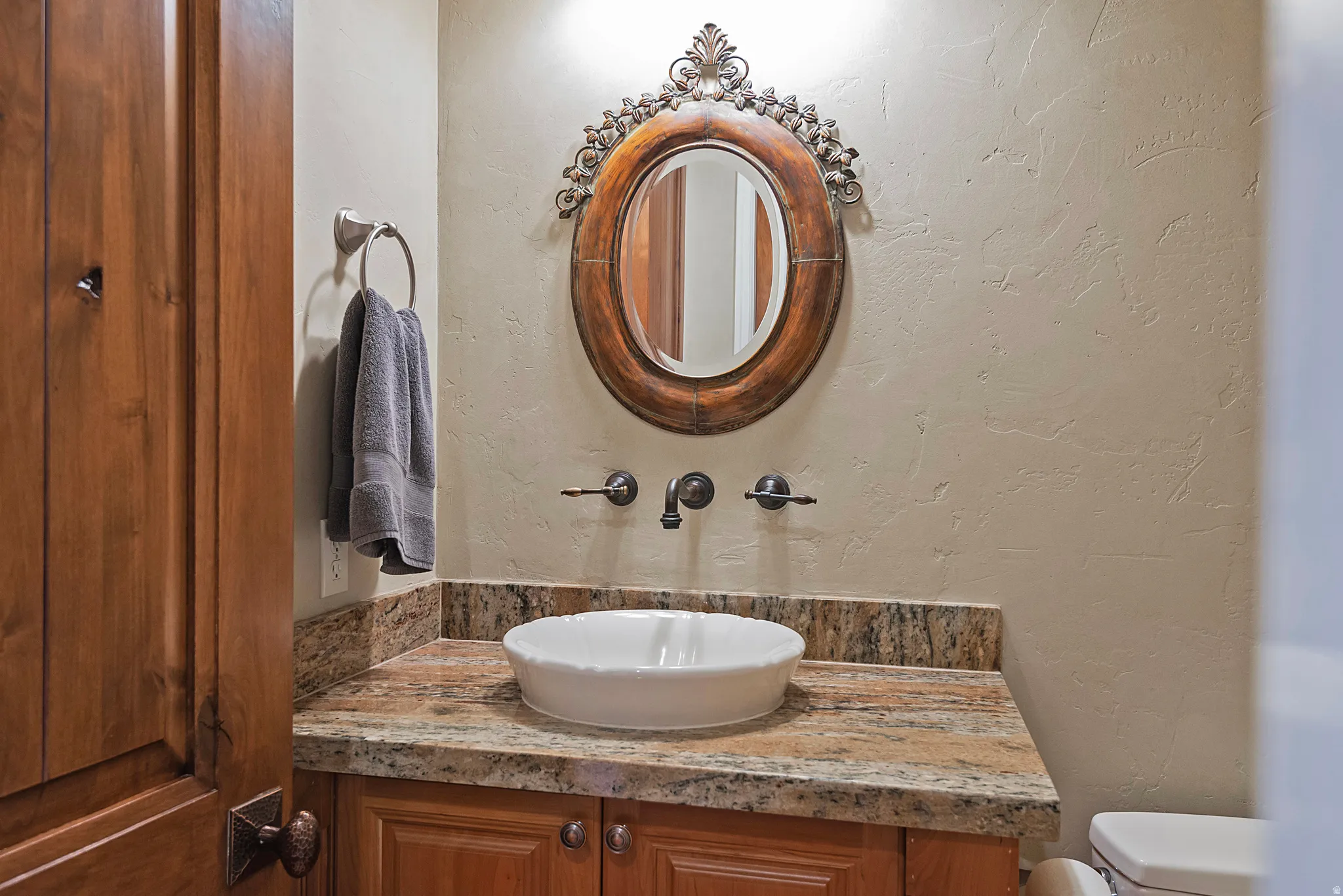 Bathroom with a textured wall and vanity