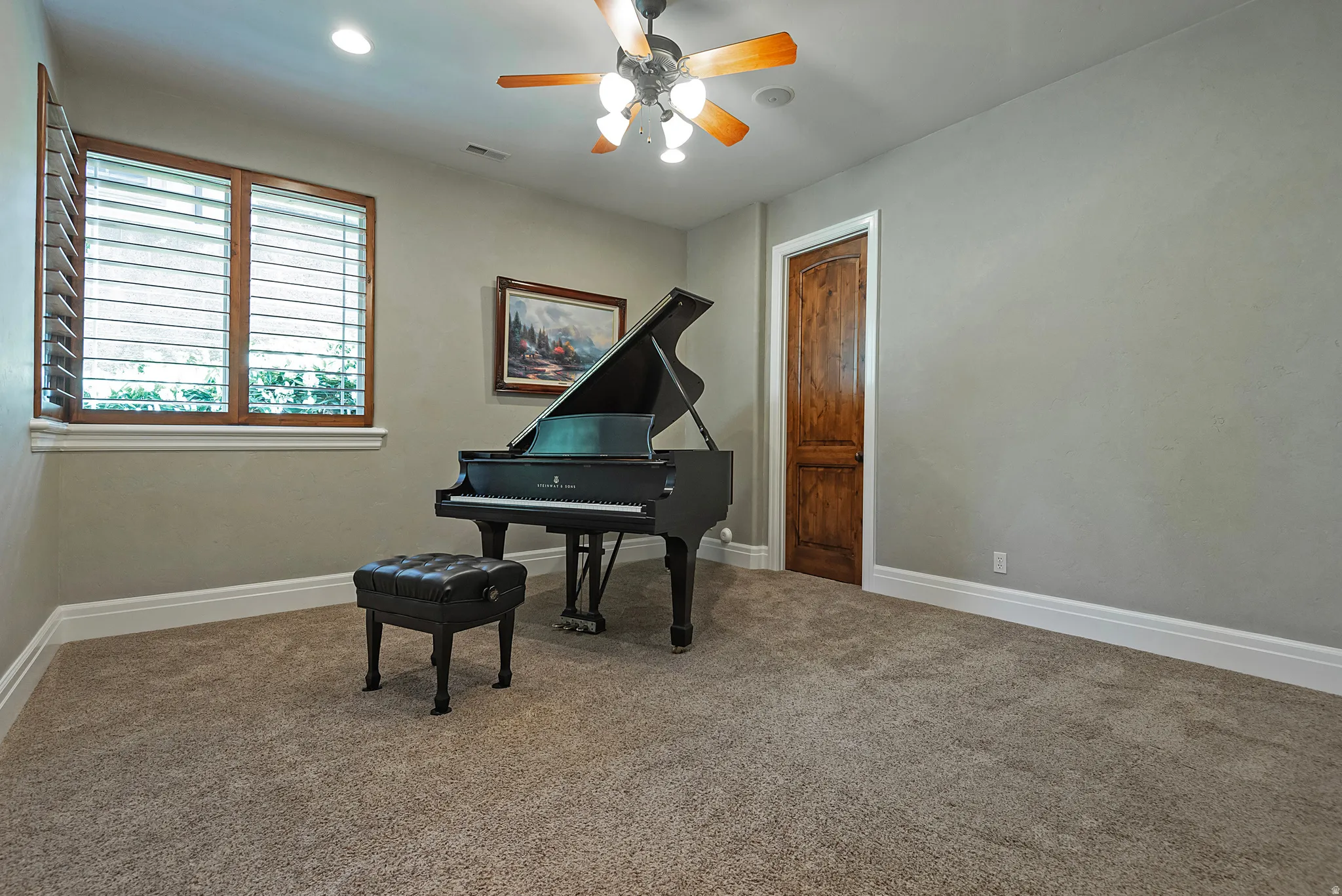 Living area with carpet, a ceiling fan, and recessed lighting