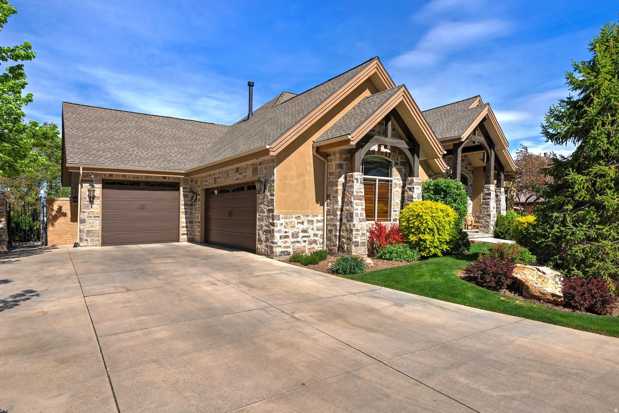 Craftsman-style house featuring stone siding, roof with shingles, and an attached garage