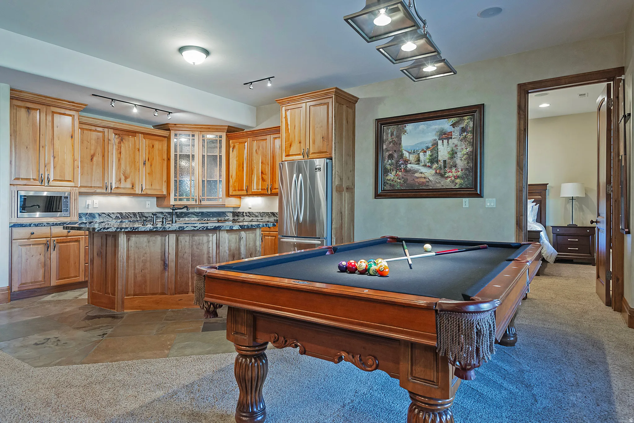 Rec room with pool table, rail lighting, and light stone finish floors