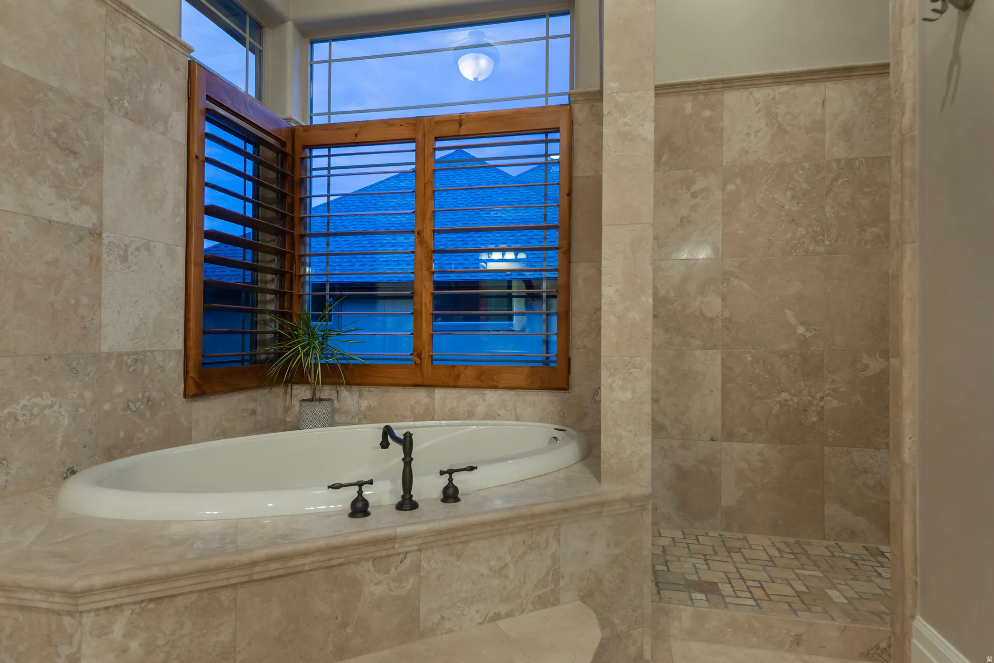 Bathroom with a bath, walk in shower, and tile walls