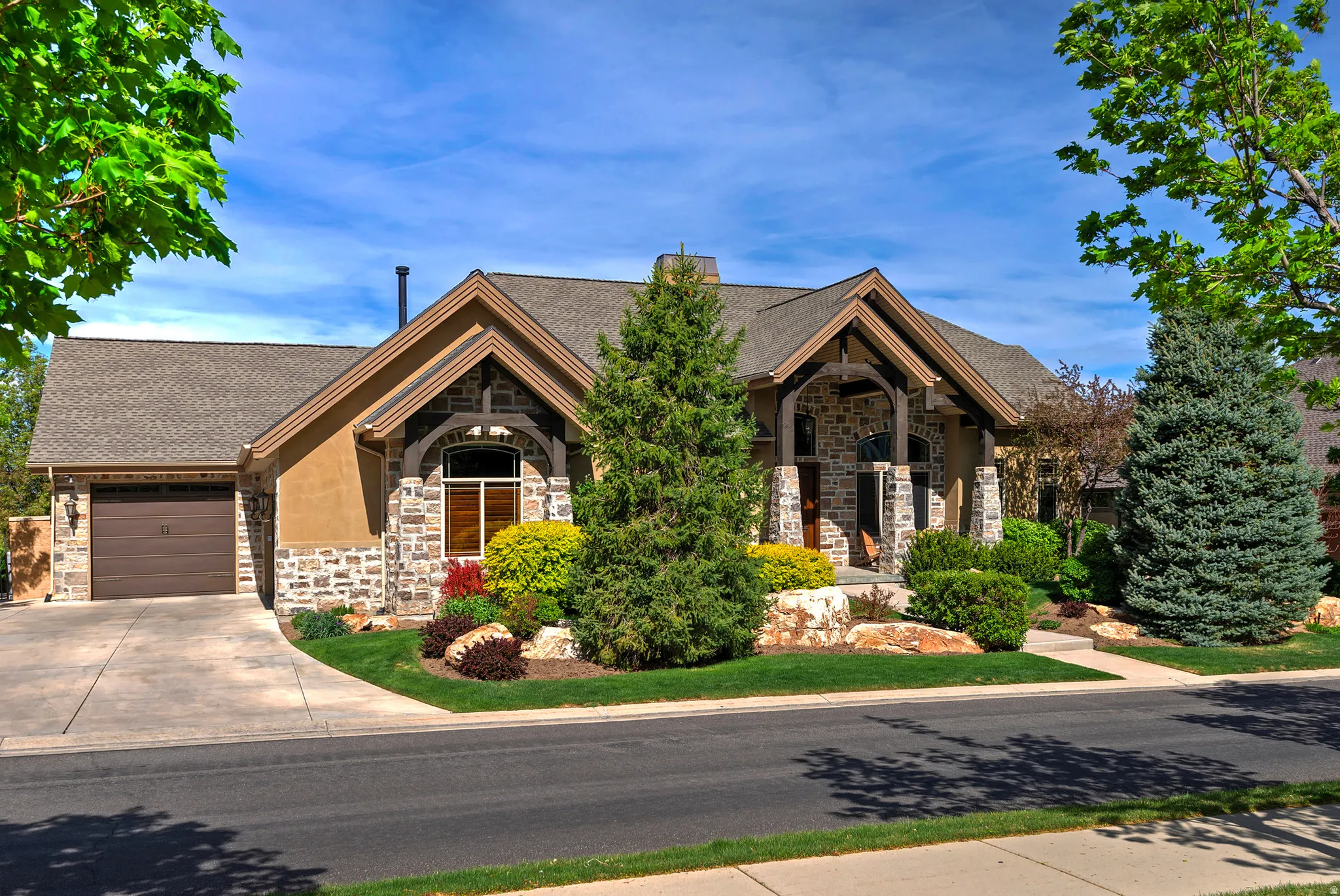 Craftsman inspired home with stone siding, a shingled roof, a garage, and driveway