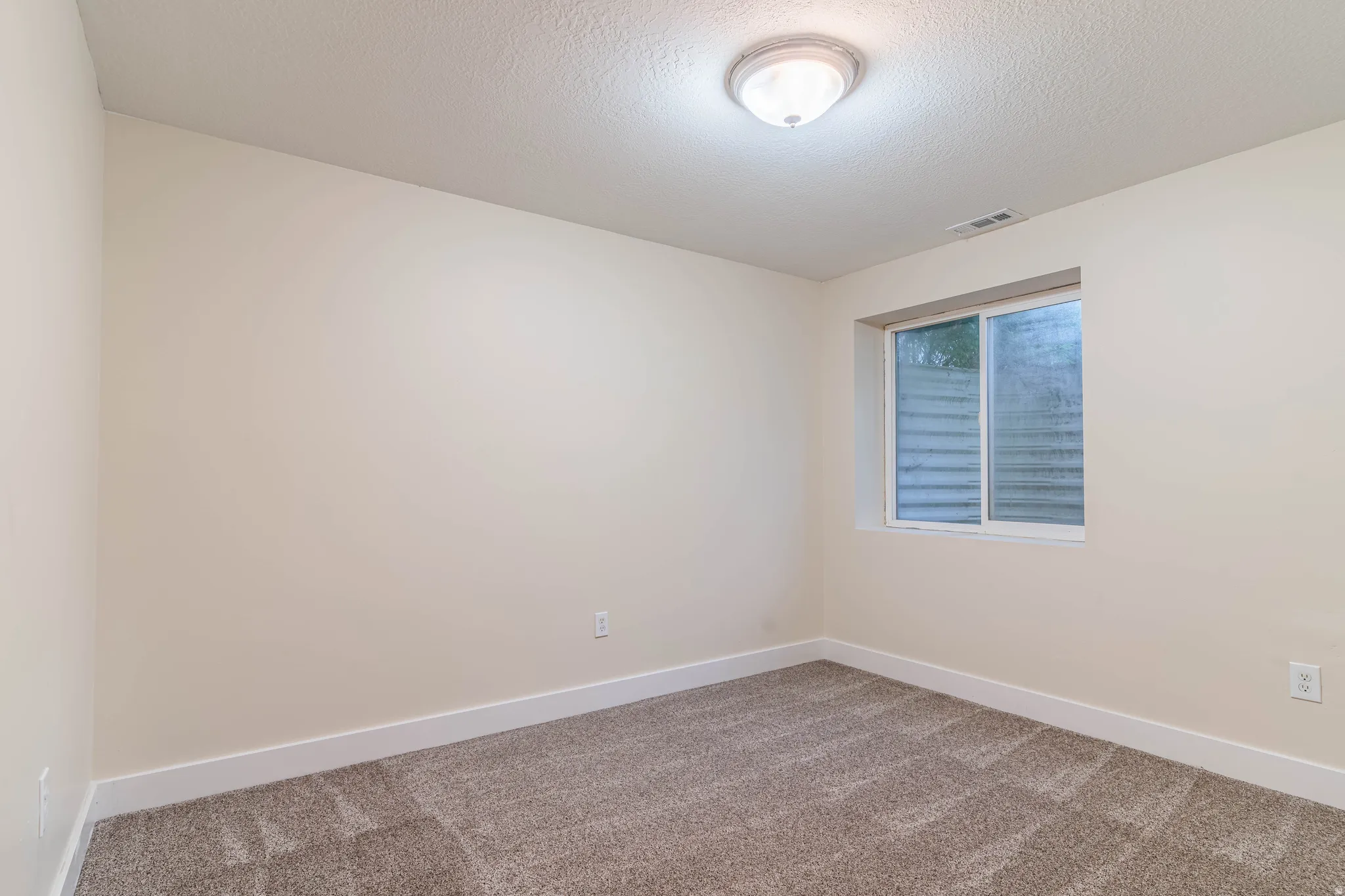 Empty room featuring carpet floors and a textured ceiling