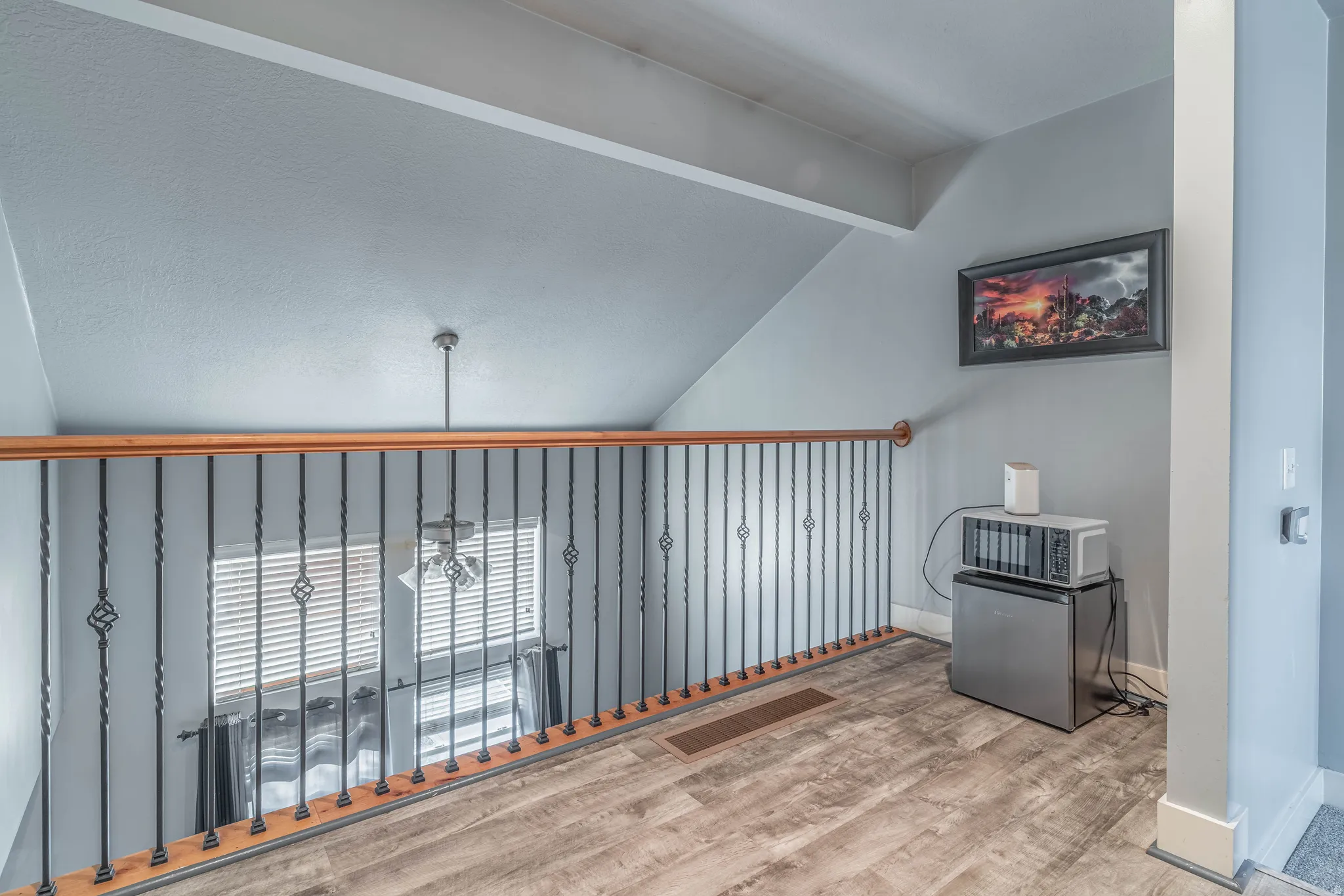 Additional living space featuring lofted ceiling with beams and wood finished floors