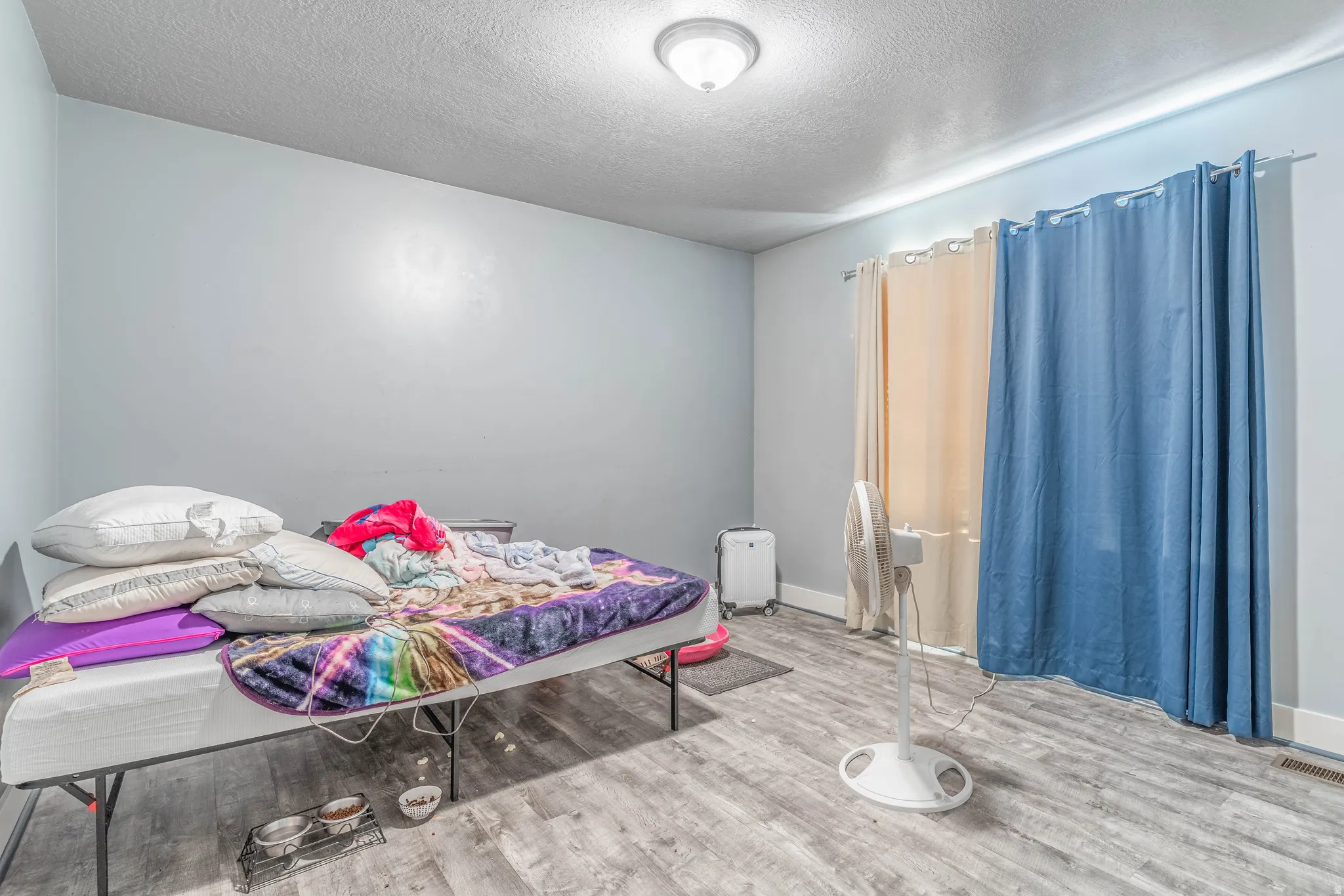 Bedroom featuring a textured ceiling and light wood-style floors