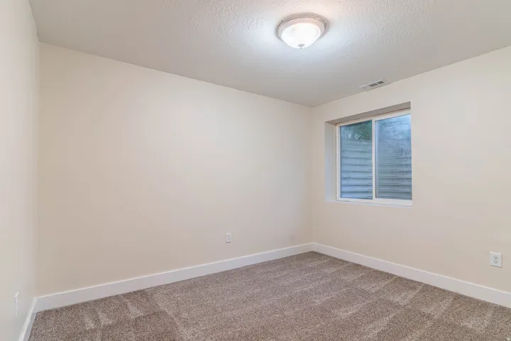 Empty room featuring carpet floors and a textured ceiling