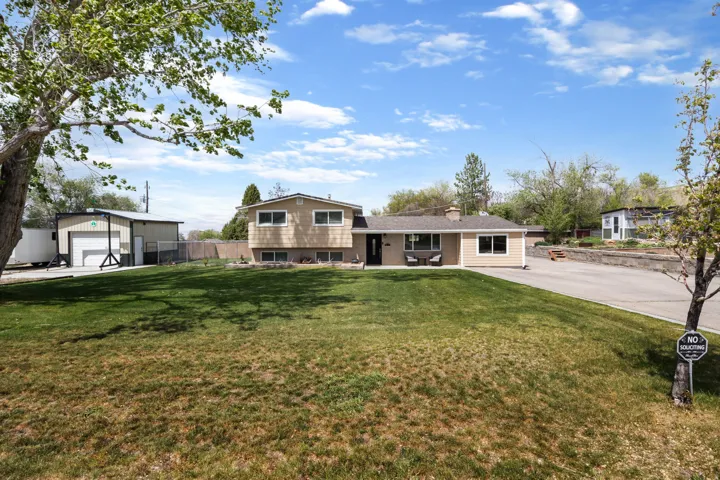 Tri-level home with an outdoor structure, a garage, and a chimney