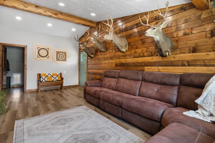 Living area featuring wood walls, wood finished floors, lofted ceiling with beams, and recessed lighting