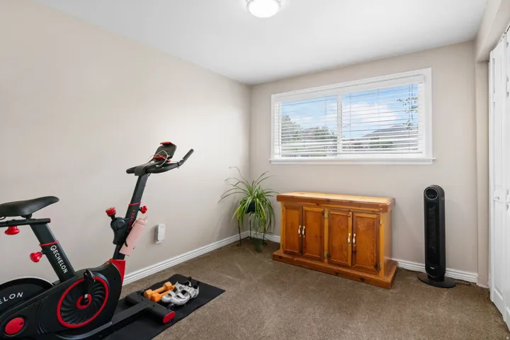 Workout room featuring dark carpet and baseboards