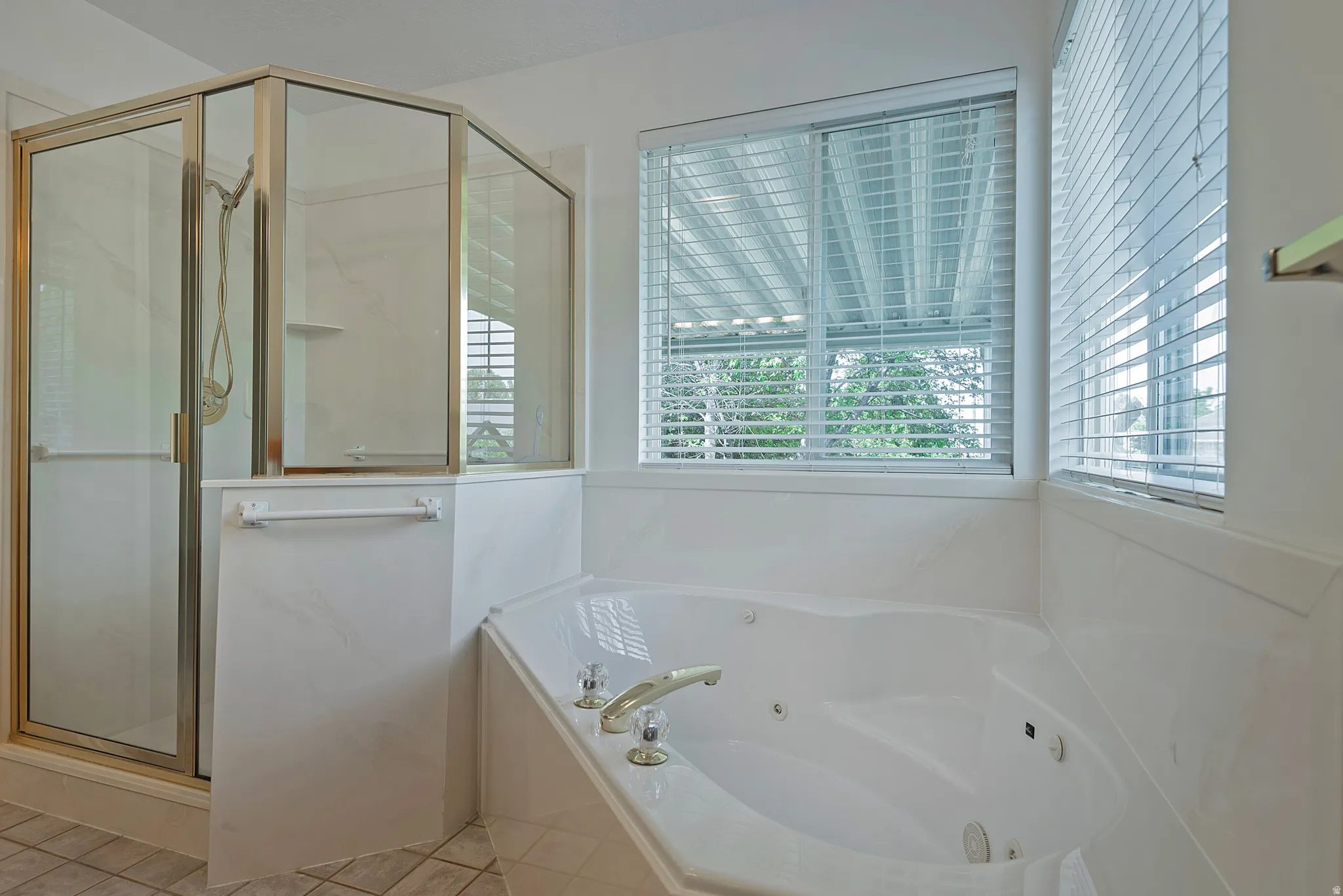 Full bathroom featuring a marble finish shower and a whirlpool tub