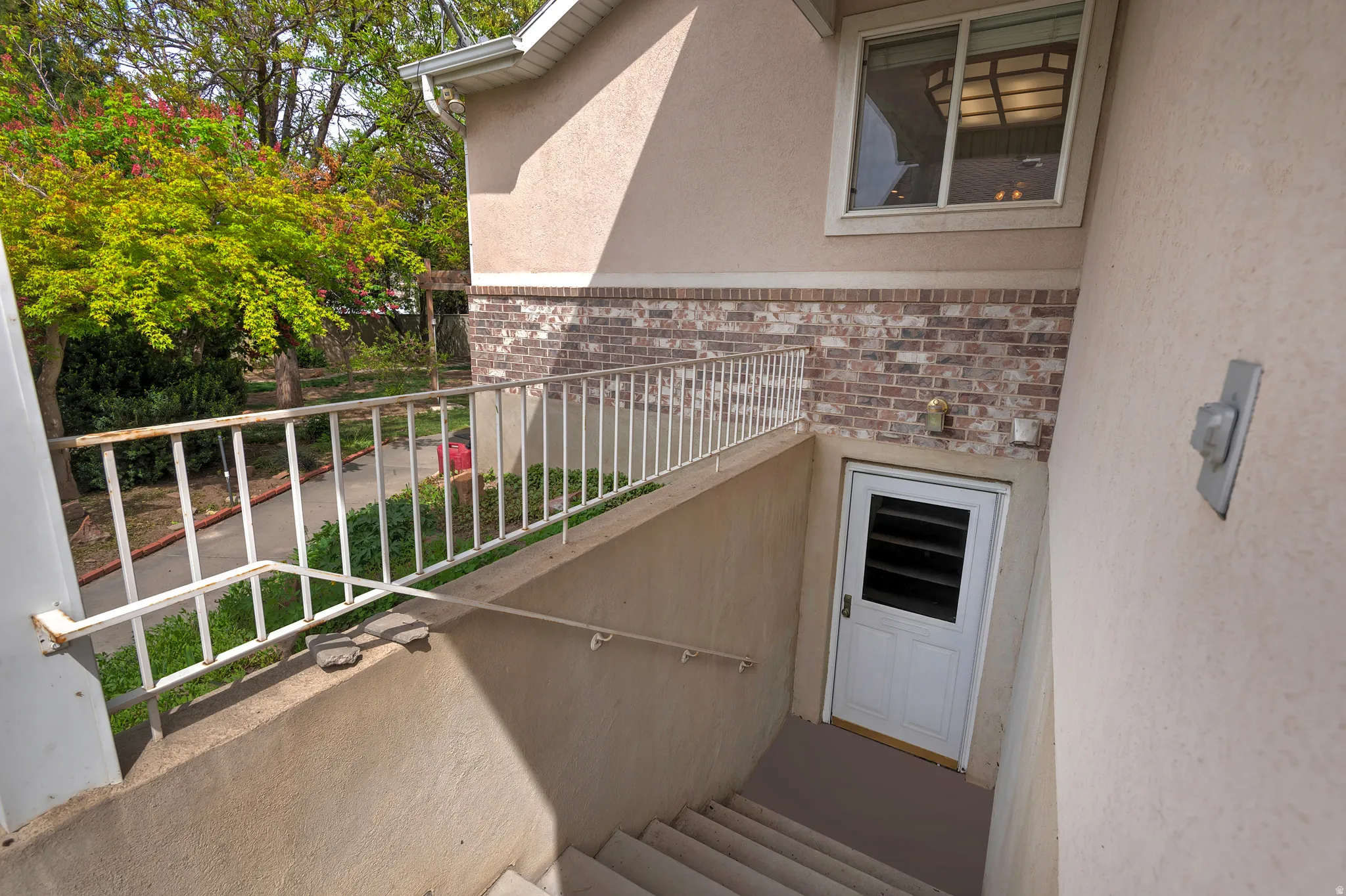 Entrance to property with brick siding and stucco siding