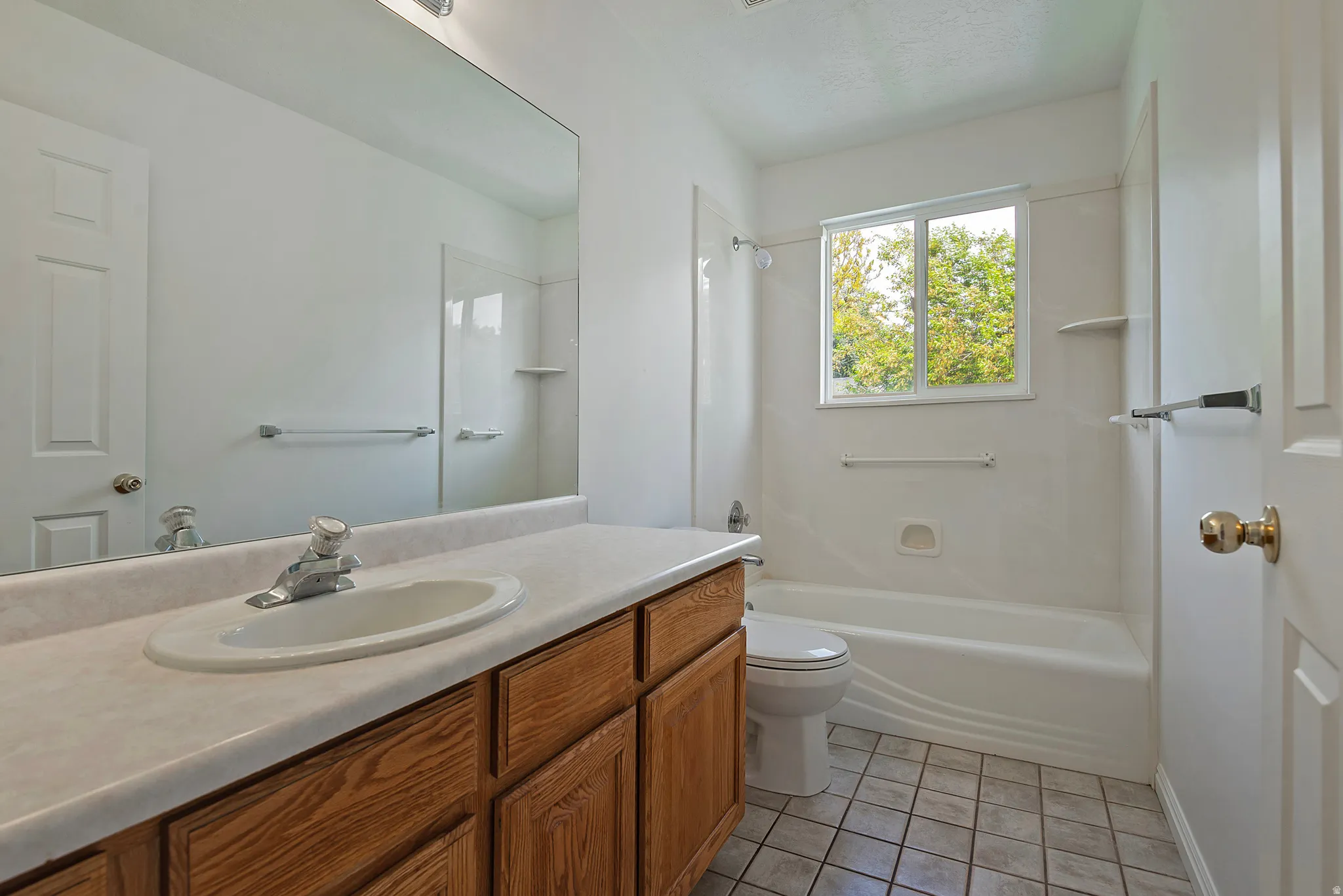 Bathroom with vanity, light tile patterned floors, and tub / shower combination