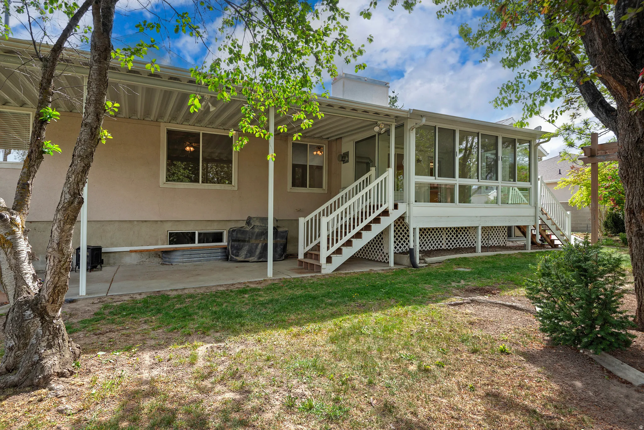 Back of house with a sunroom and a yard