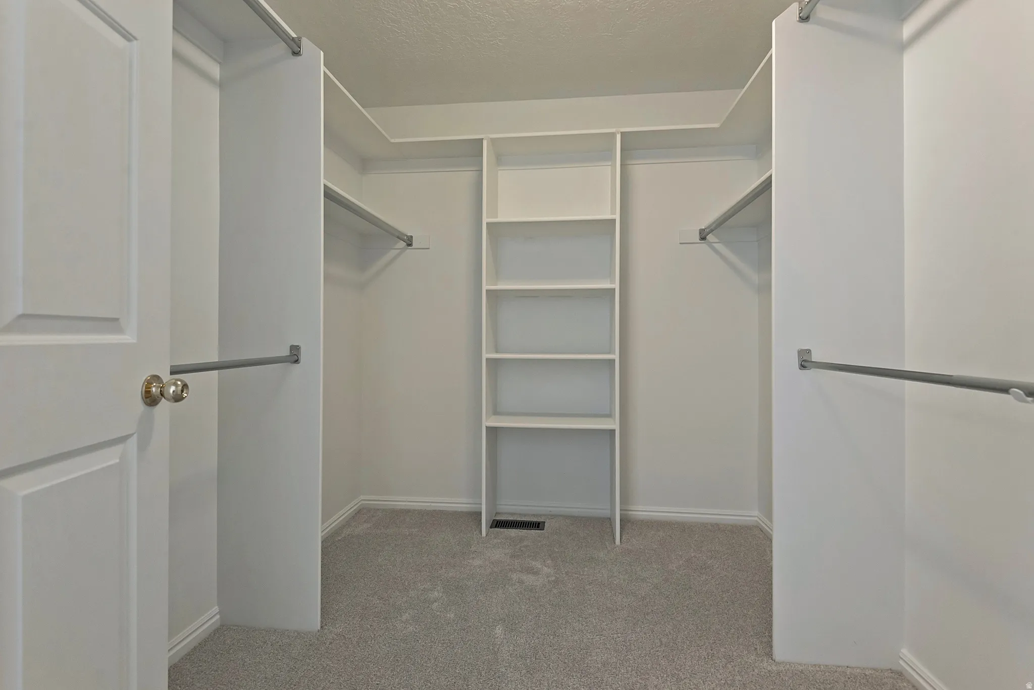 Walk in closet with light colored carpet
