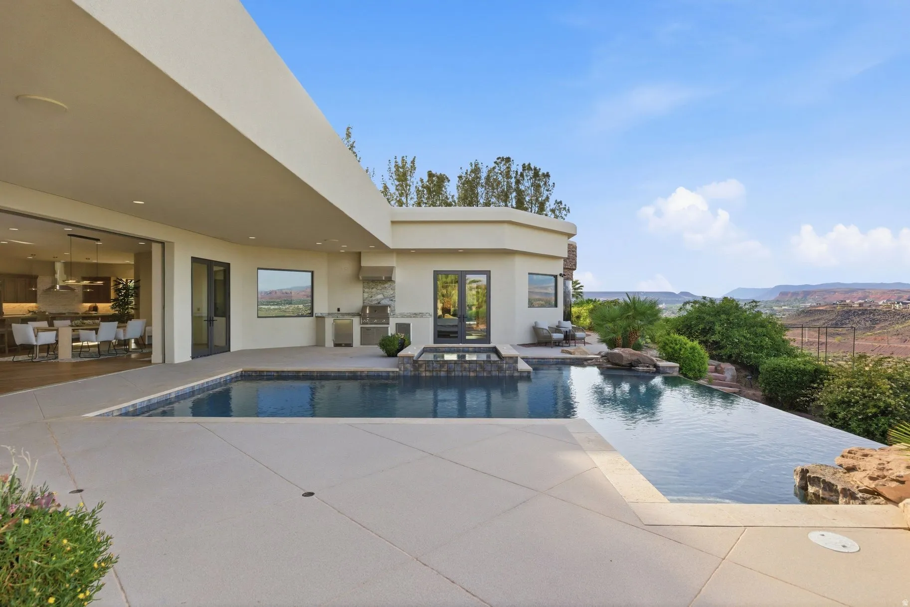 Combined pool / hot tub with a patio area and area for grilling