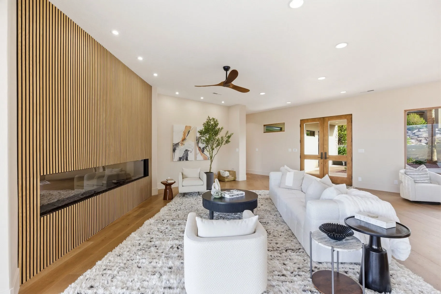 Living area featuring light wood-type flooring, recessed lighting, a glass covered fireplace, ceiling fan, and french doors