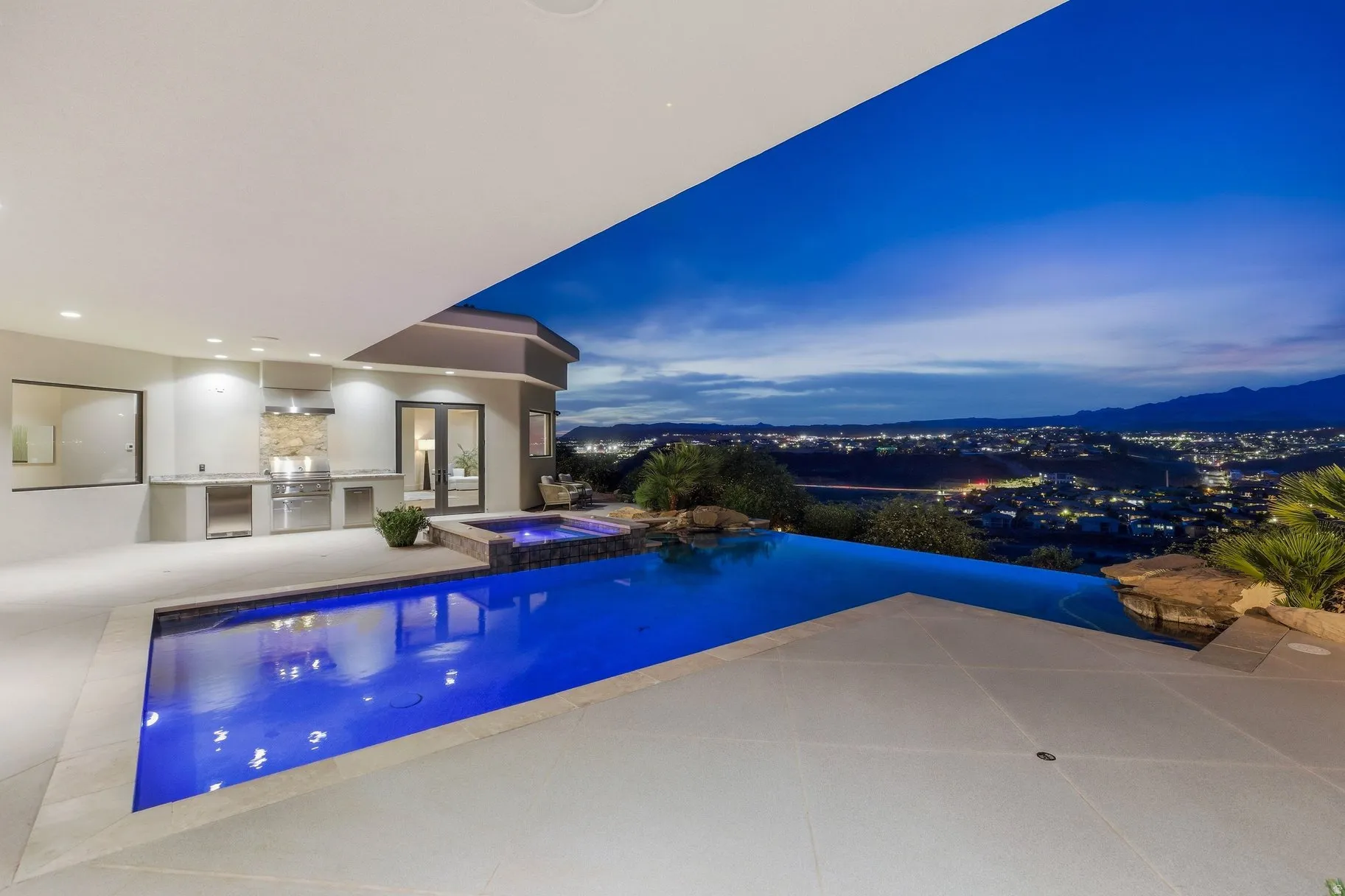 Integrated pool / spa featuring an outdoor kitchen and a patio