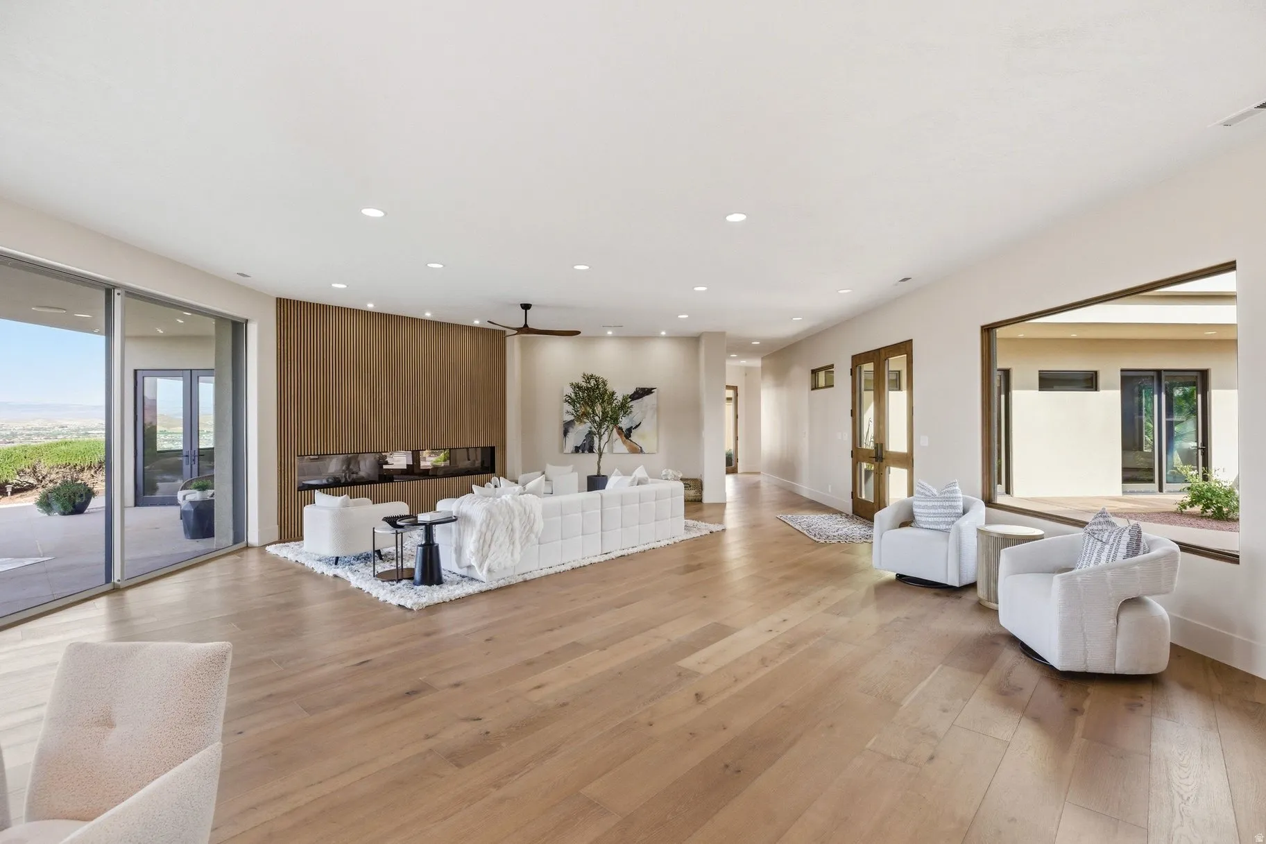 Living area featuring light wood finished floors, a ceiling fan, and recessed lighting