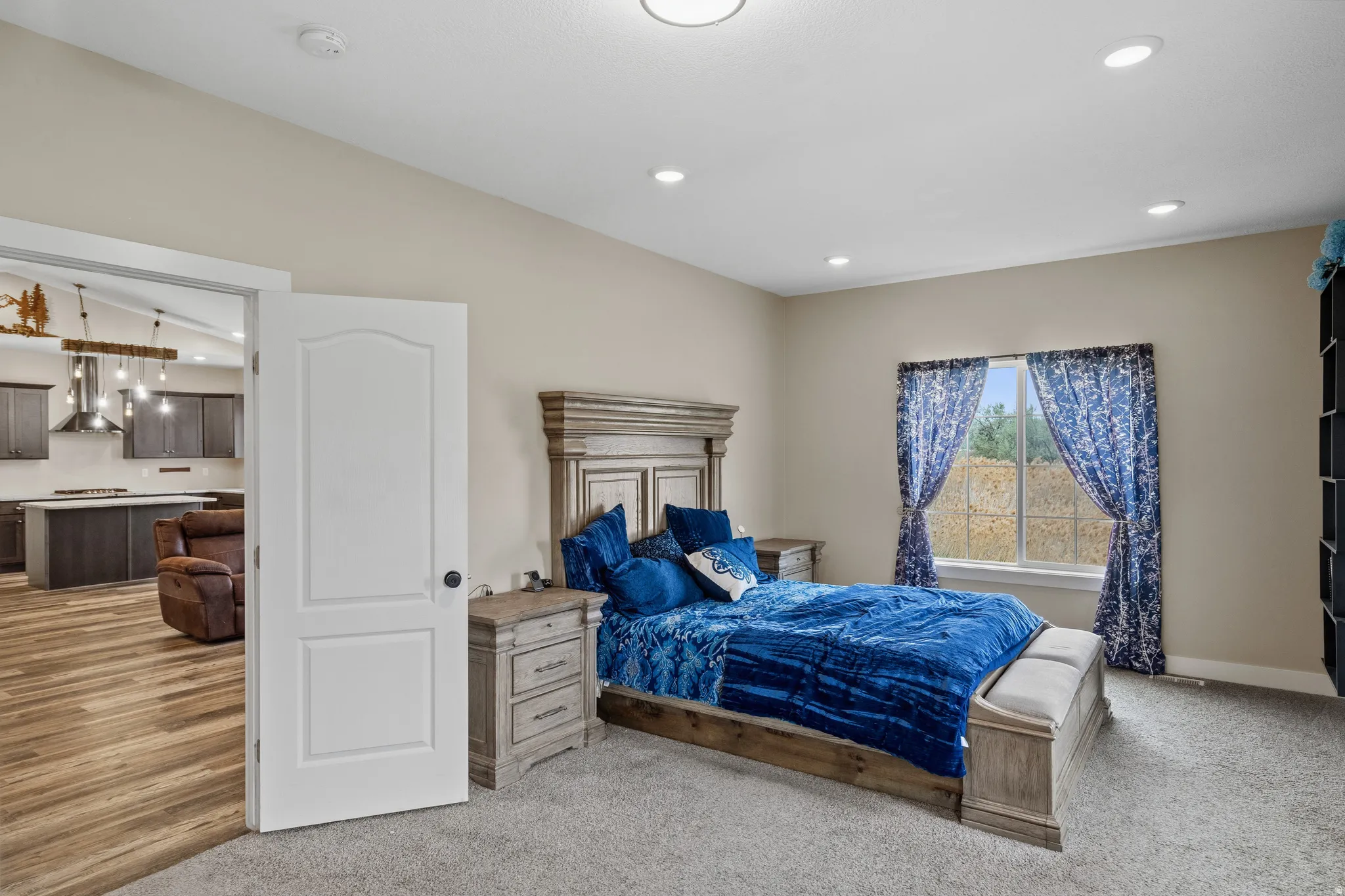 Bedroom featuring light carpet, vaulted ceiling, and recessed lighting