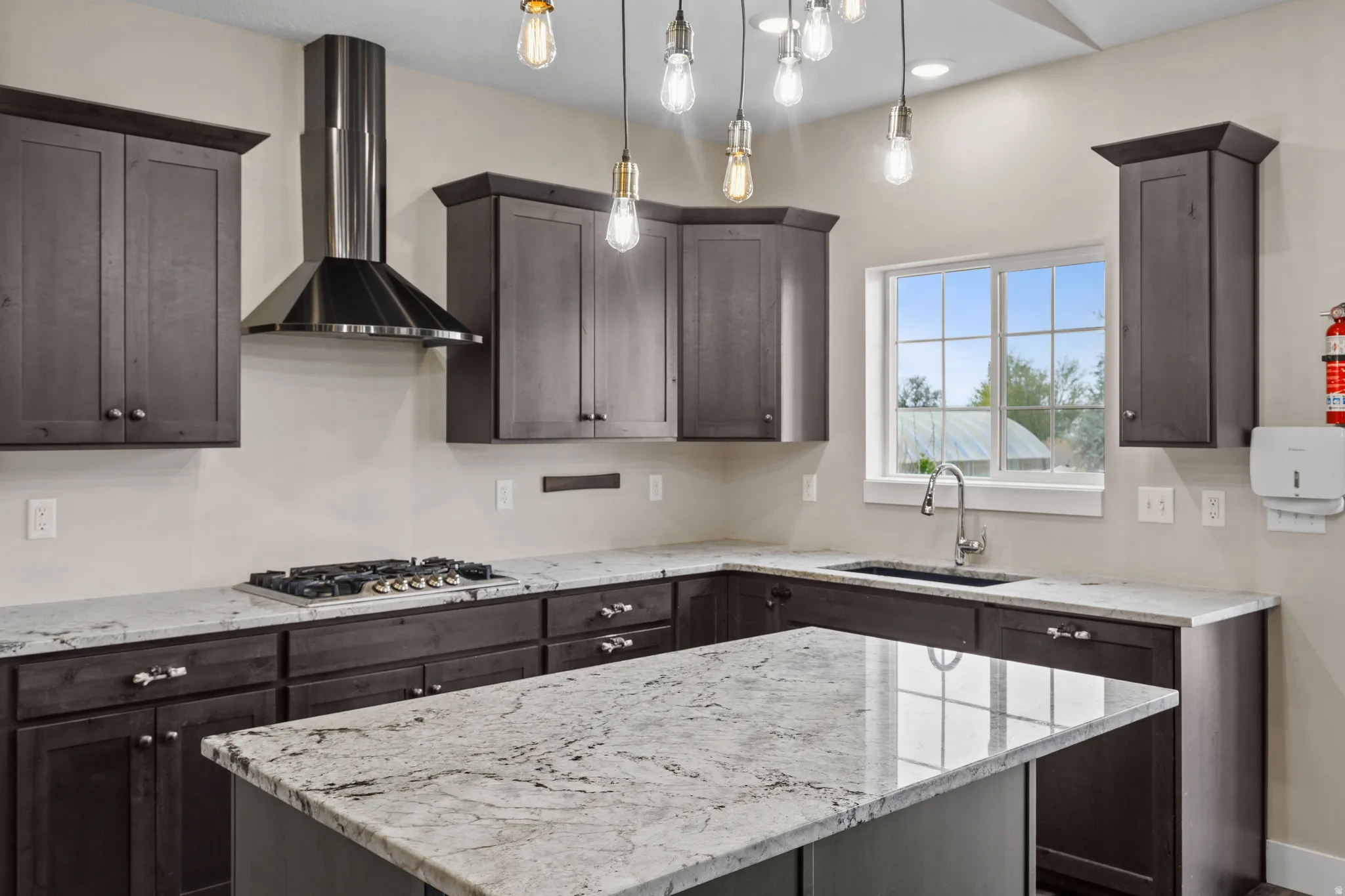 Kitchen featuring light stone countertops, dark wood finish cabinets, and a kitchen island